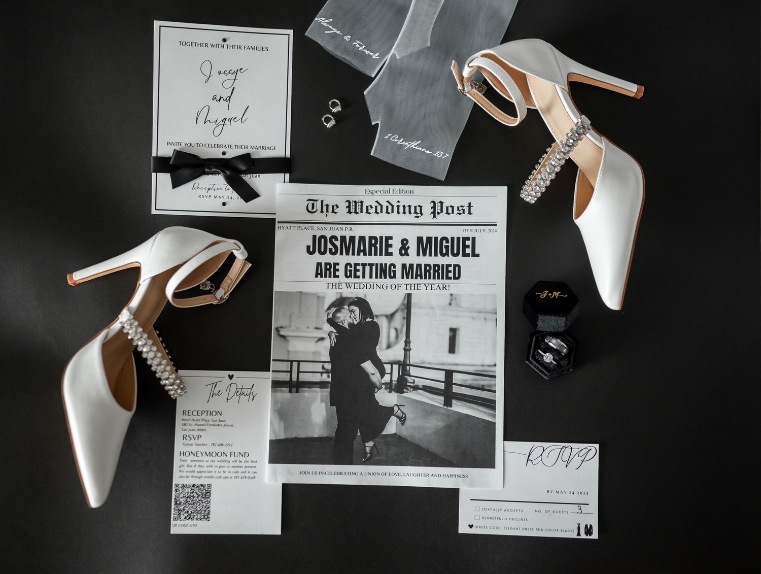 Wedding invitation suite with white heels and black bow accessories arranged on dark background.