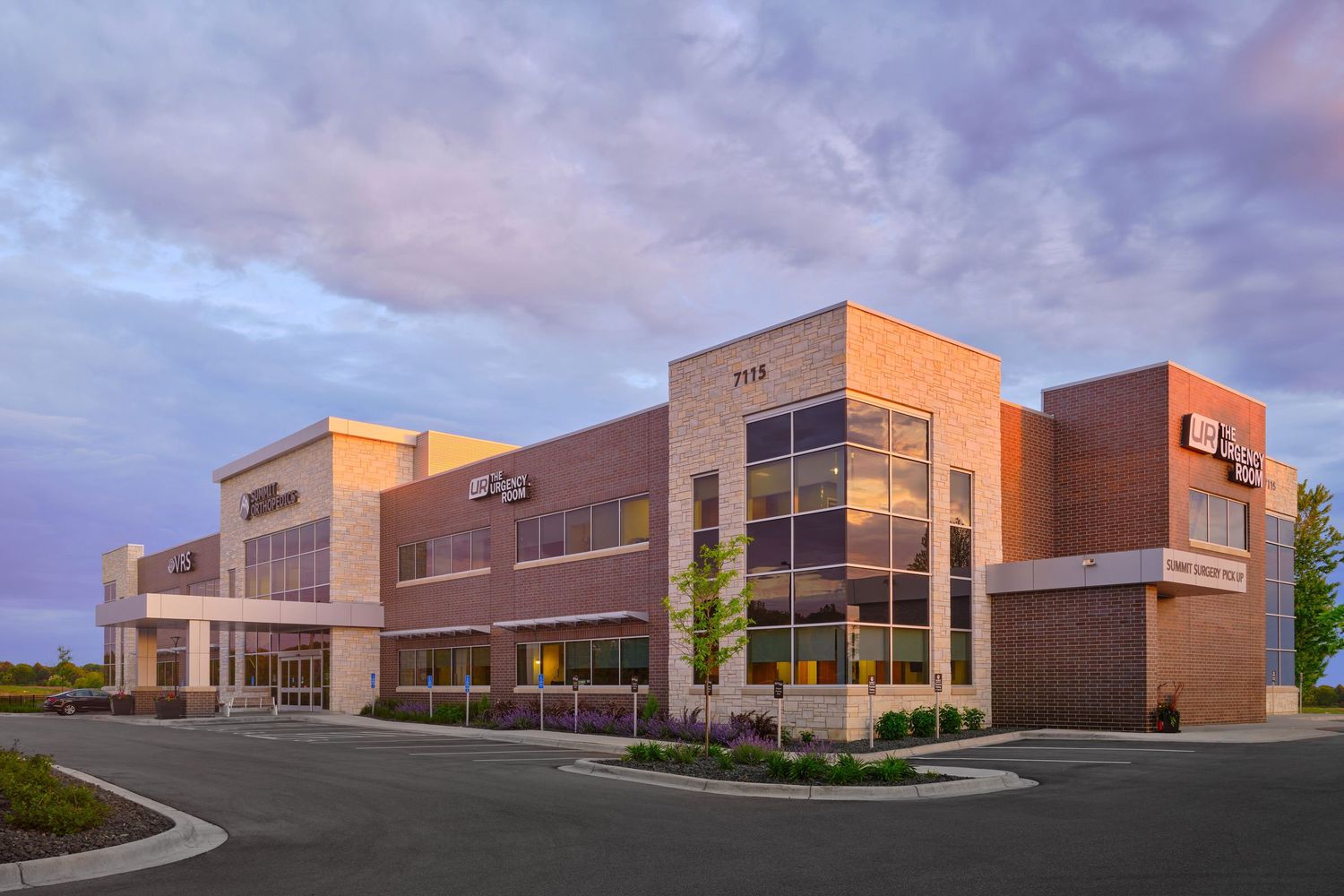 Modern medical building exterior at dusk with warm lighting and contemporary architecture.