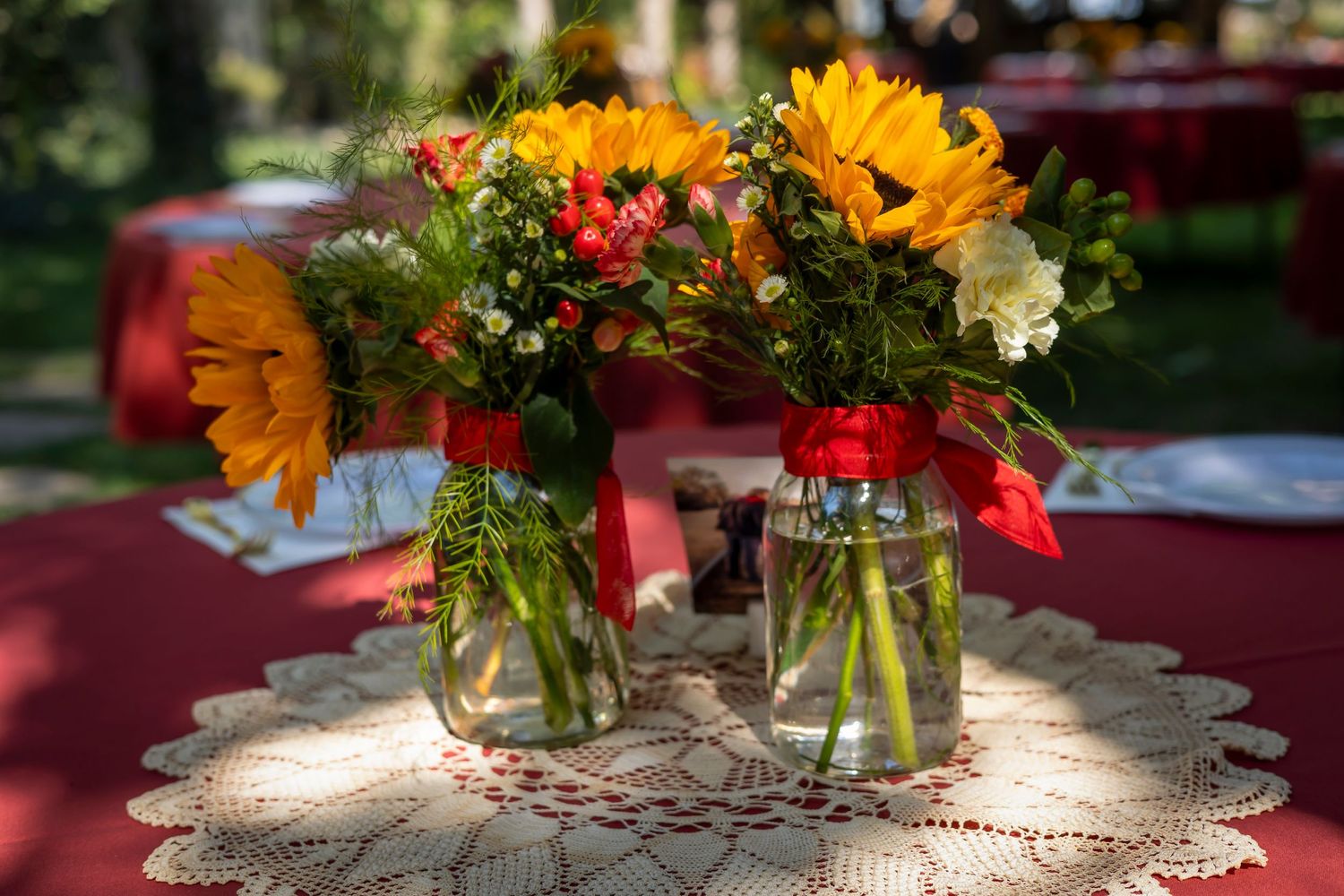 Red table decor with sunflowers in mason jars