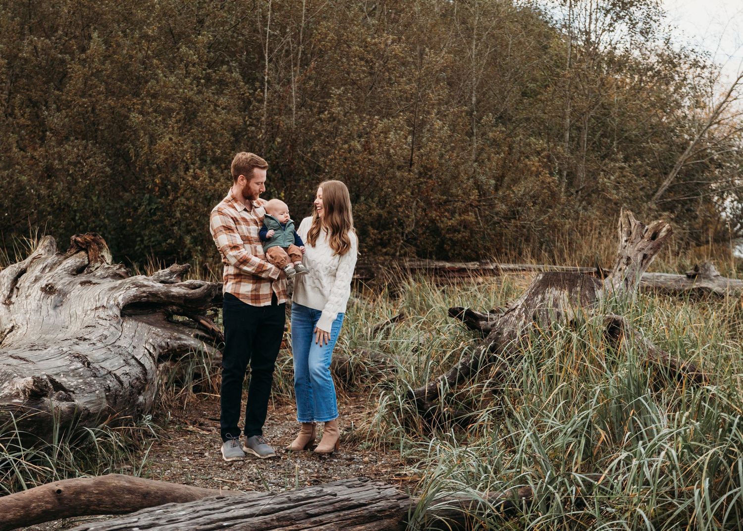 A sequence of outdoor fall photos shows a family sitting together on driftwood along a shoreline during golden hour.