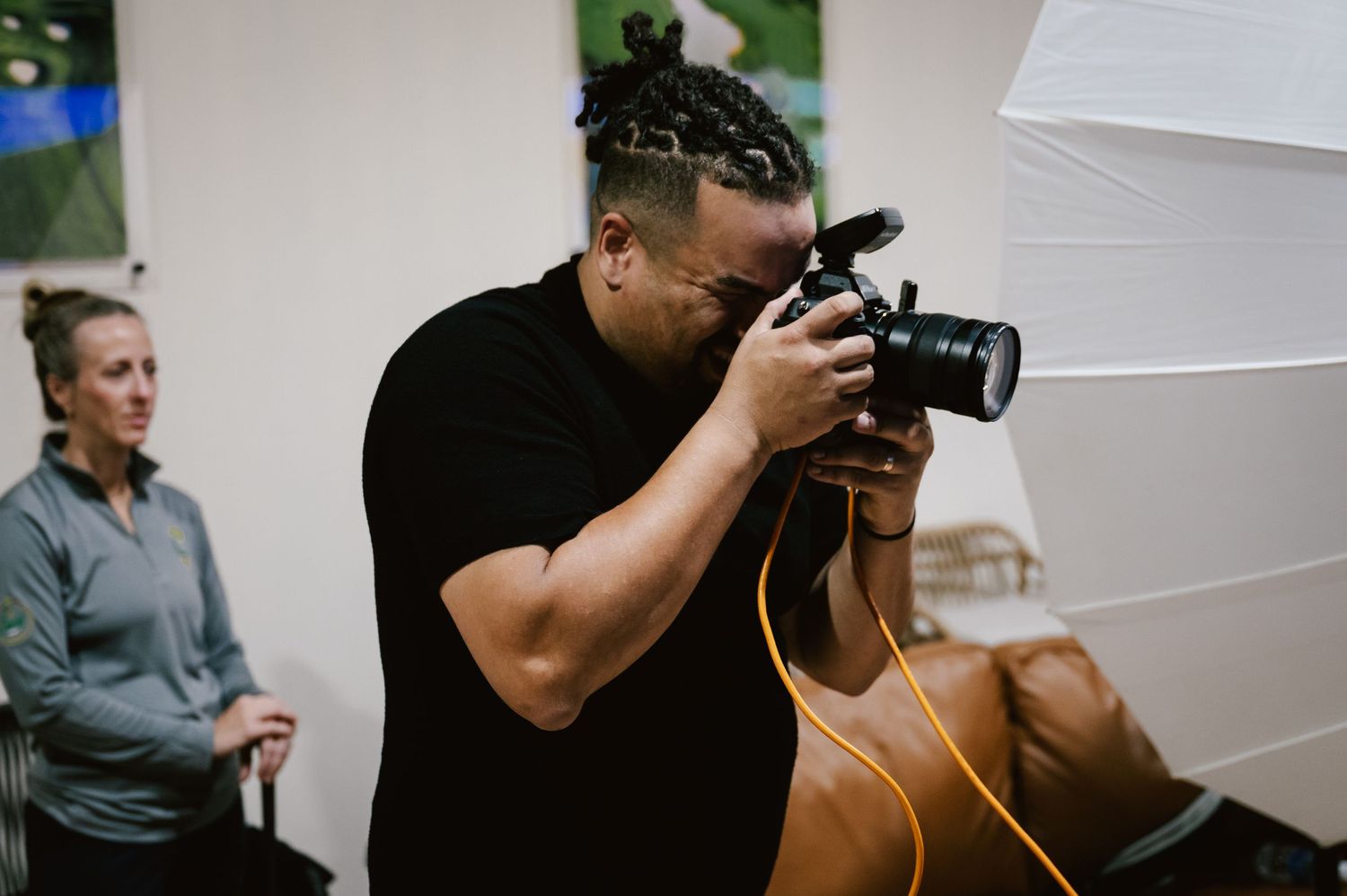 Multiple photographers capturing shots in a bright indoor studio space.