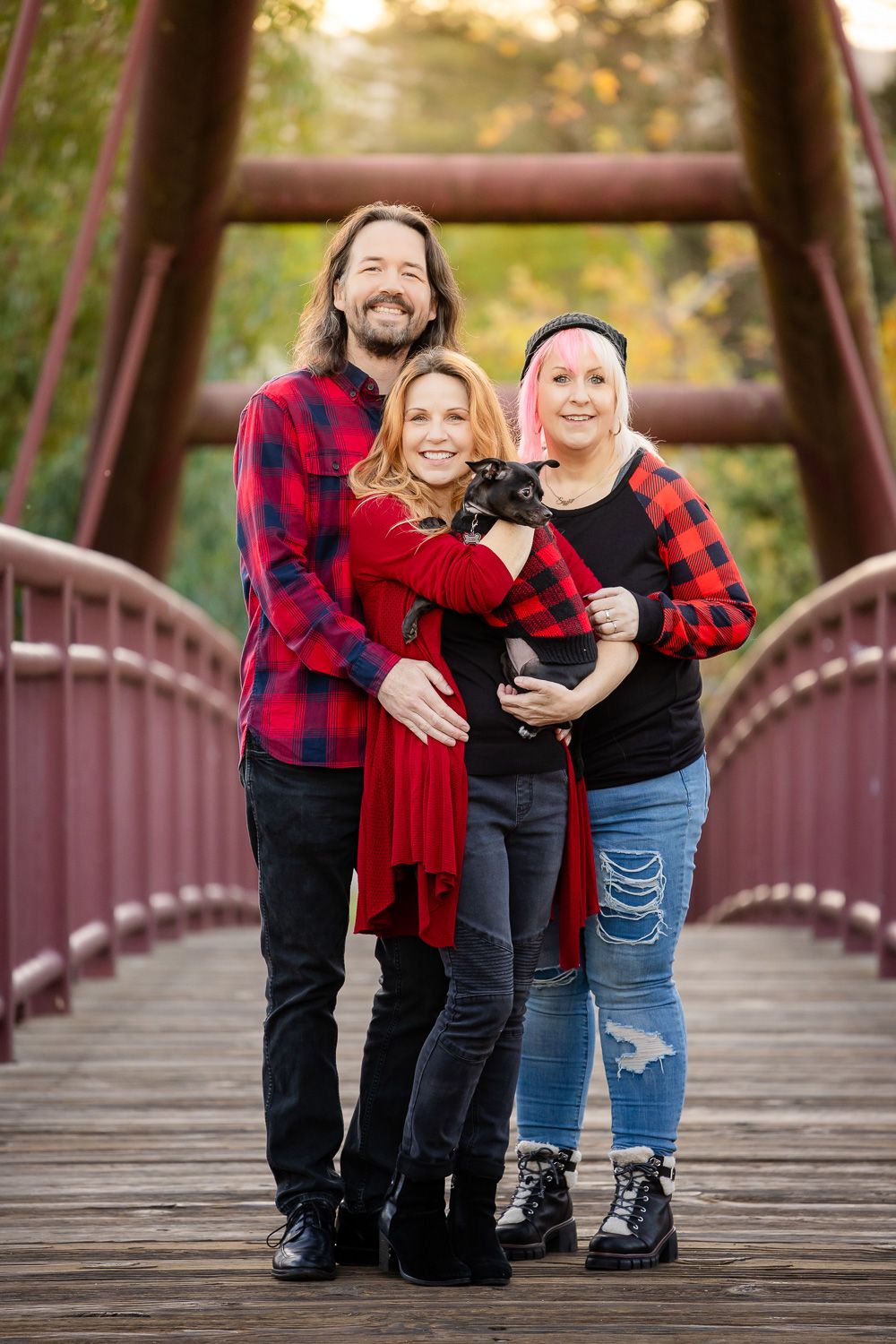 Bay Area Photographer Cindy Tucey photographs three adults and a dog on a red bridge in Vasona Lake Park in Los Gatos