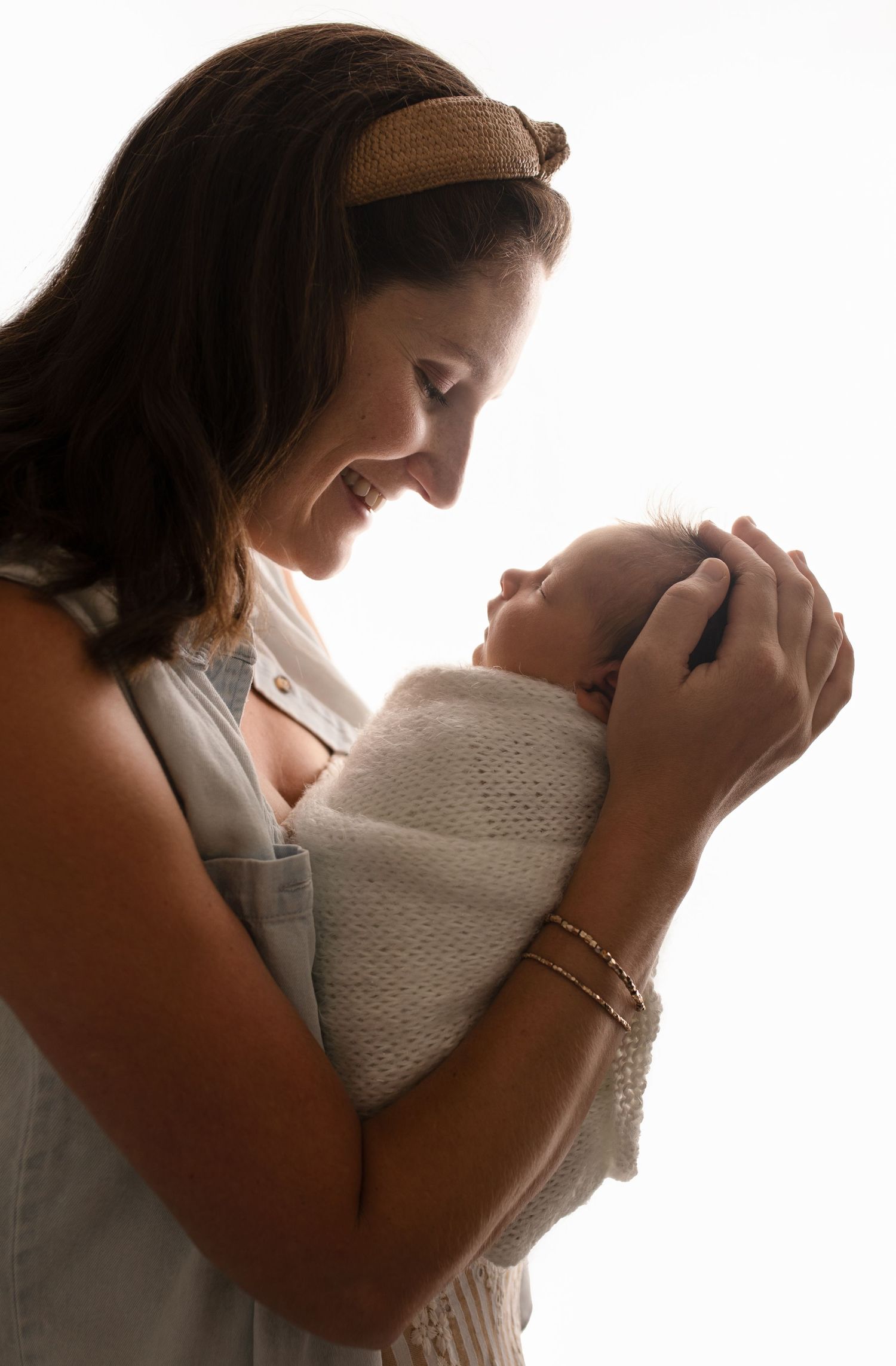 Charlottesville photographer, newborn, baby, family, maternity, new mom looks lovingly at newborn as she cradles his head.