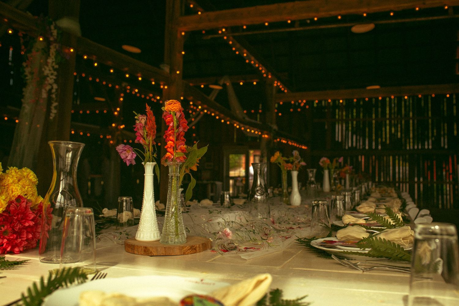 Diners enjoy a meal in a rustic restaurant with warm lighting and large windows letting in natural sunlight.