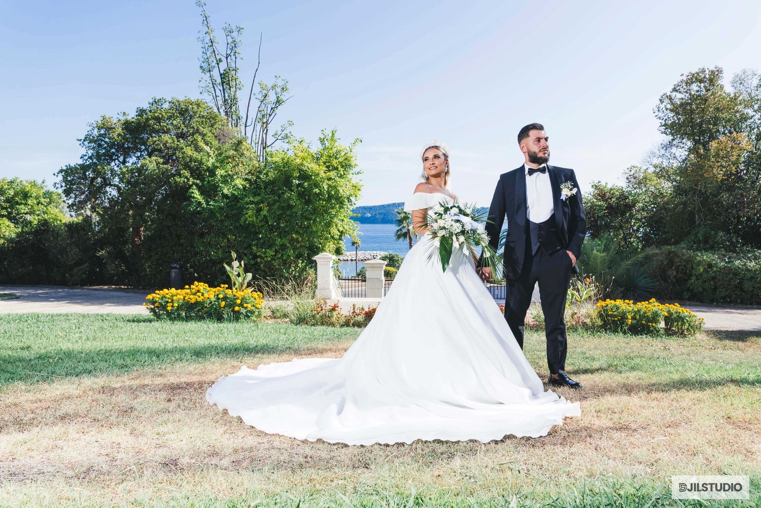 Wedding couple walking together through a scenic outdoor garden setting during their special day celebration.
