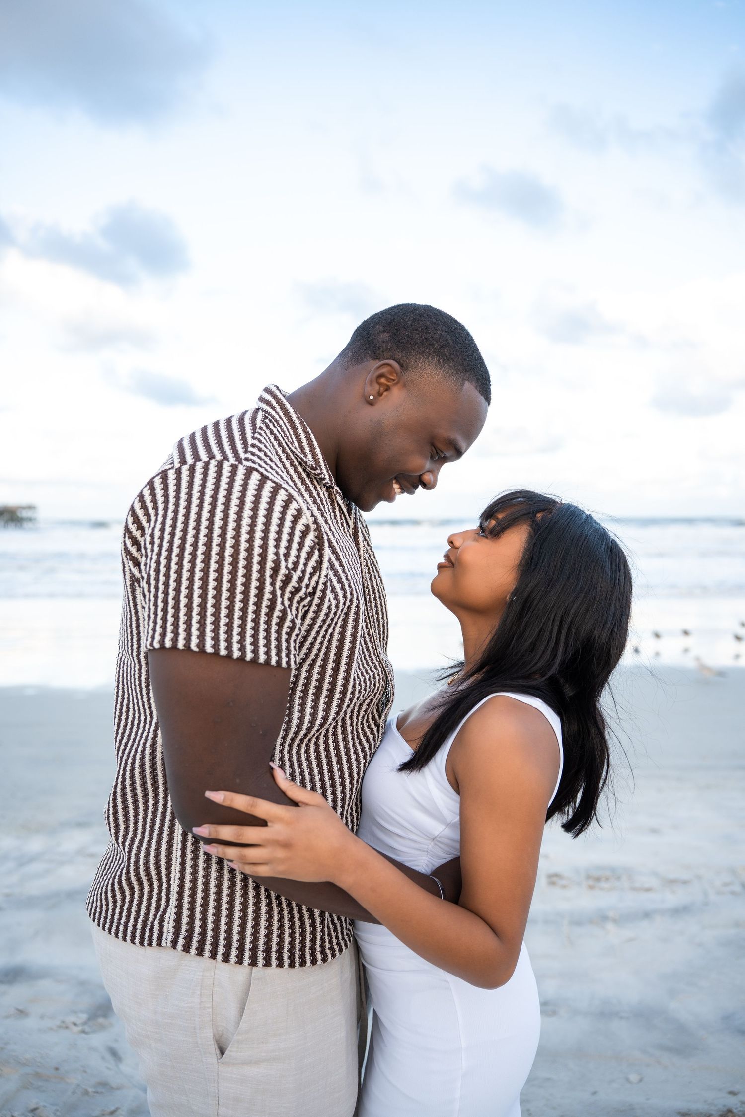 A couple embraces lovingly on a peaceful beach at sunset, creating a romantic seaside moment in Daytona Beach, Florida