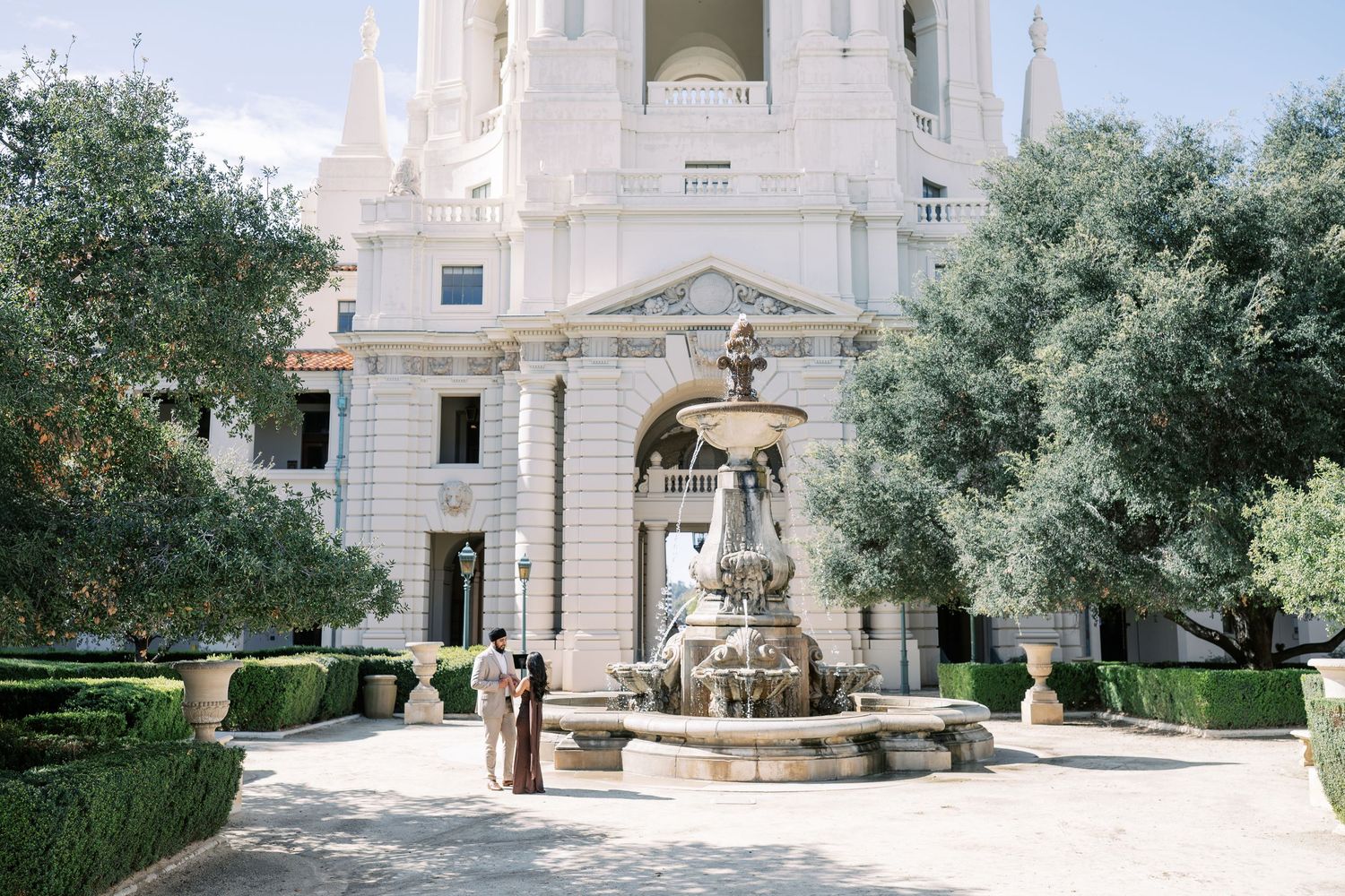 A series of exterior views showing white stone architecture and landscaped gardens at a historic religious building.
