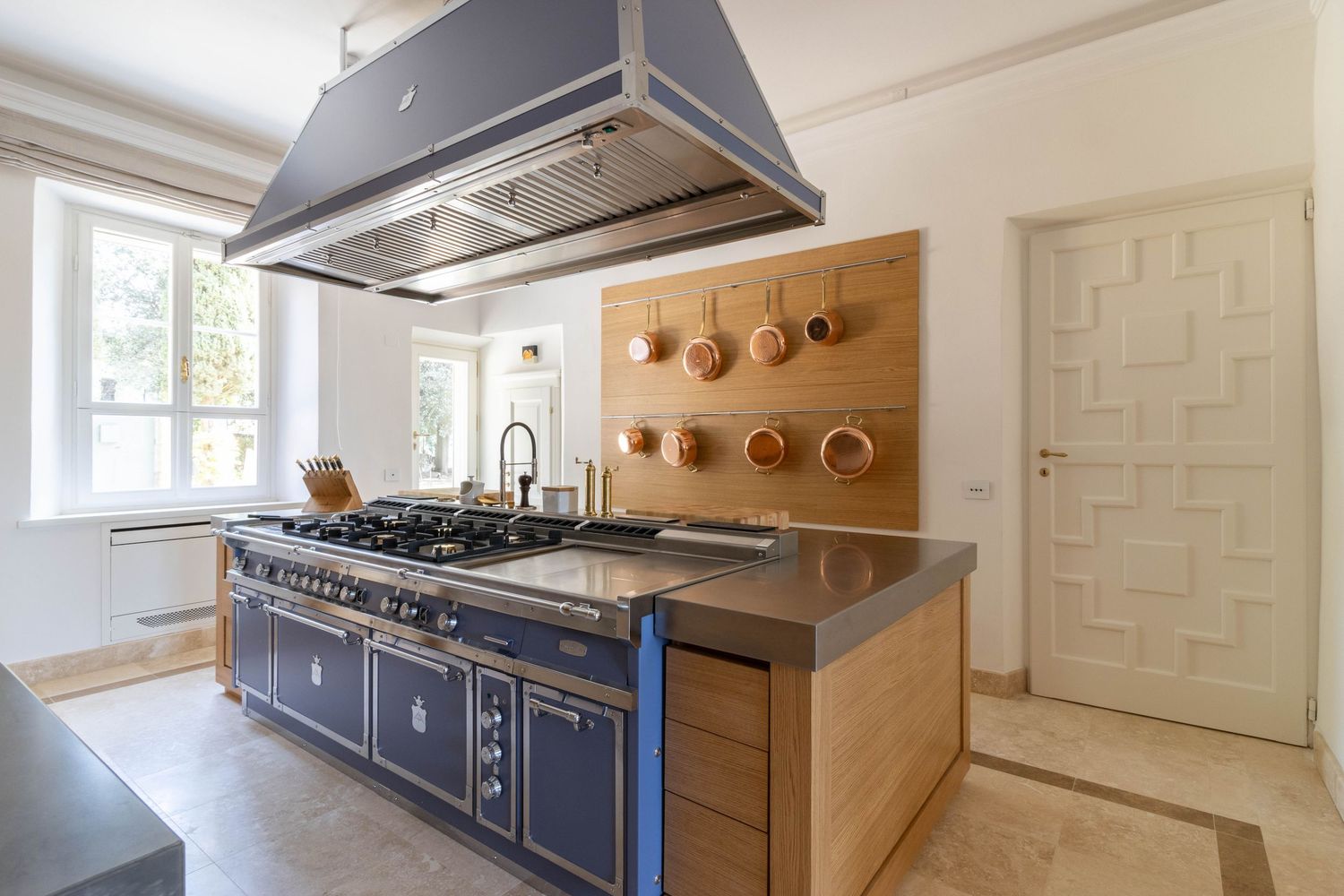 Luxury villa photographer in Lucca, Italy. Modern kitchen features sleek stainless steel appliances with natural lighting.
