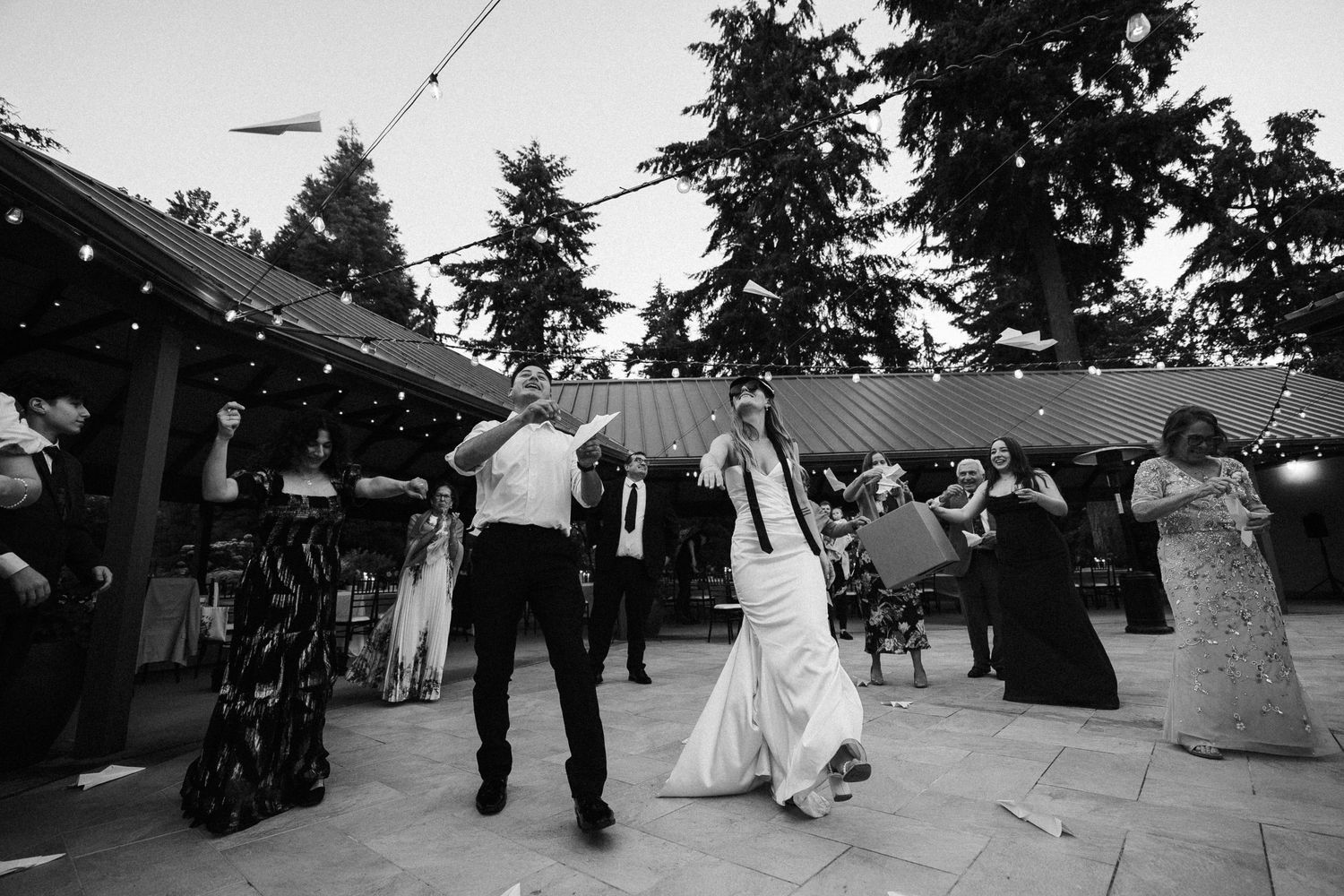 Madison and Ruben at their Froggsong Garden wedding throwing paper planes and dancing with their guest at their reception.
