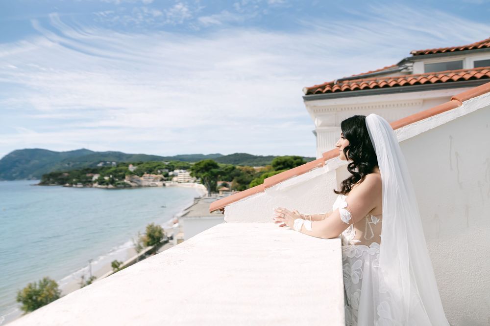 A panoramic view of a Mediterranean coastal town with white buildings and terracotta roofs overlooking blue waters.