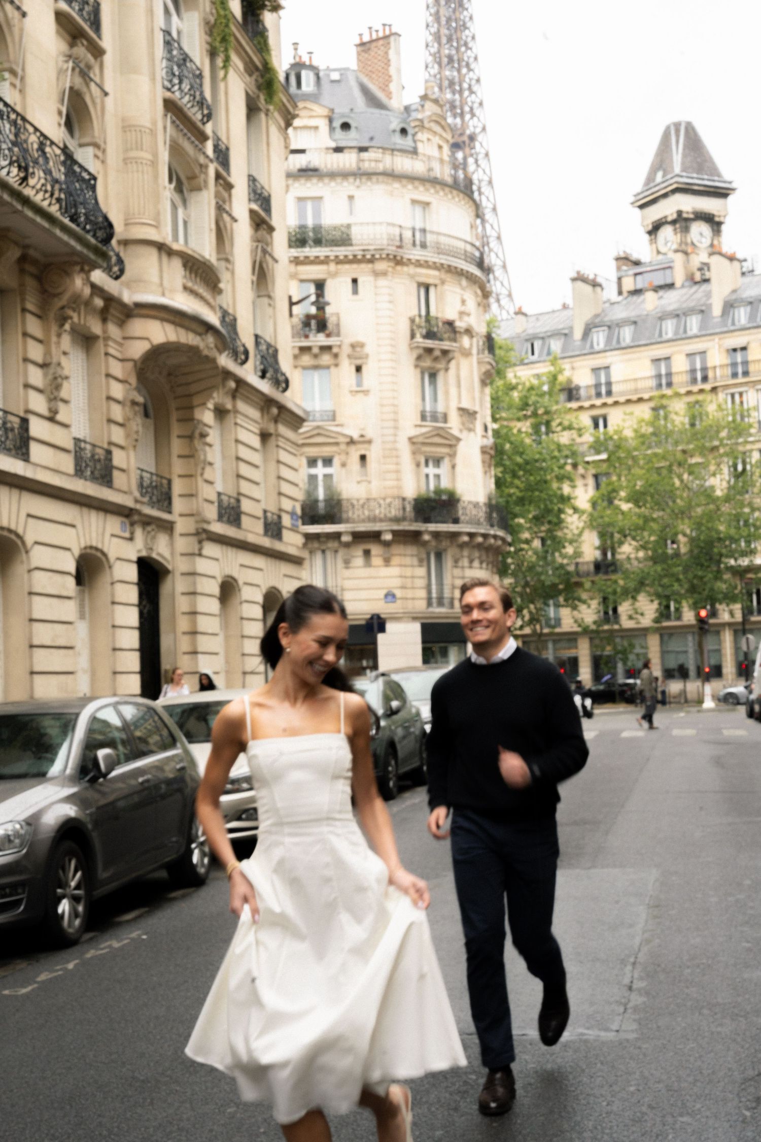 A bride in a white dress and groom in a suit pose for wedding photos in Paris with eiffel tower architecture. Paris cinematic photographer.