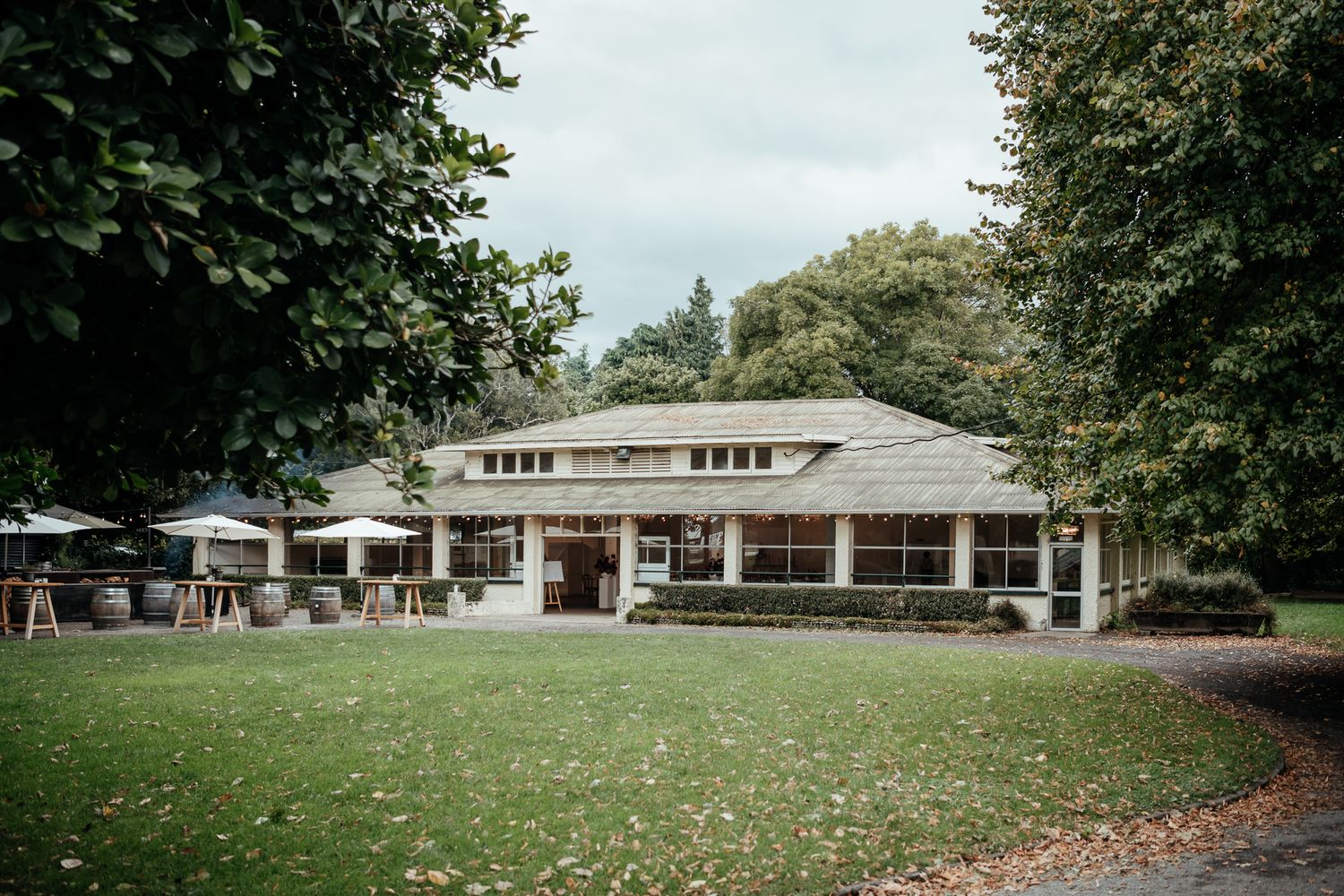 The restored Tea House building at Rose & Smith, Tauherenikau with large windows sits in front of a large lawn by August and Vine