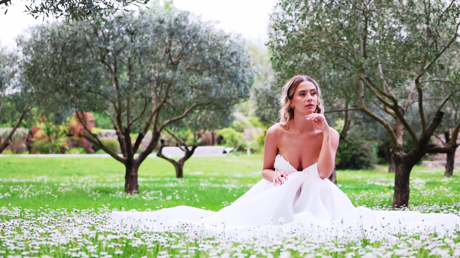 Mariée assise dans l’herbe sous les oliviers lors d’un mariage en Provence