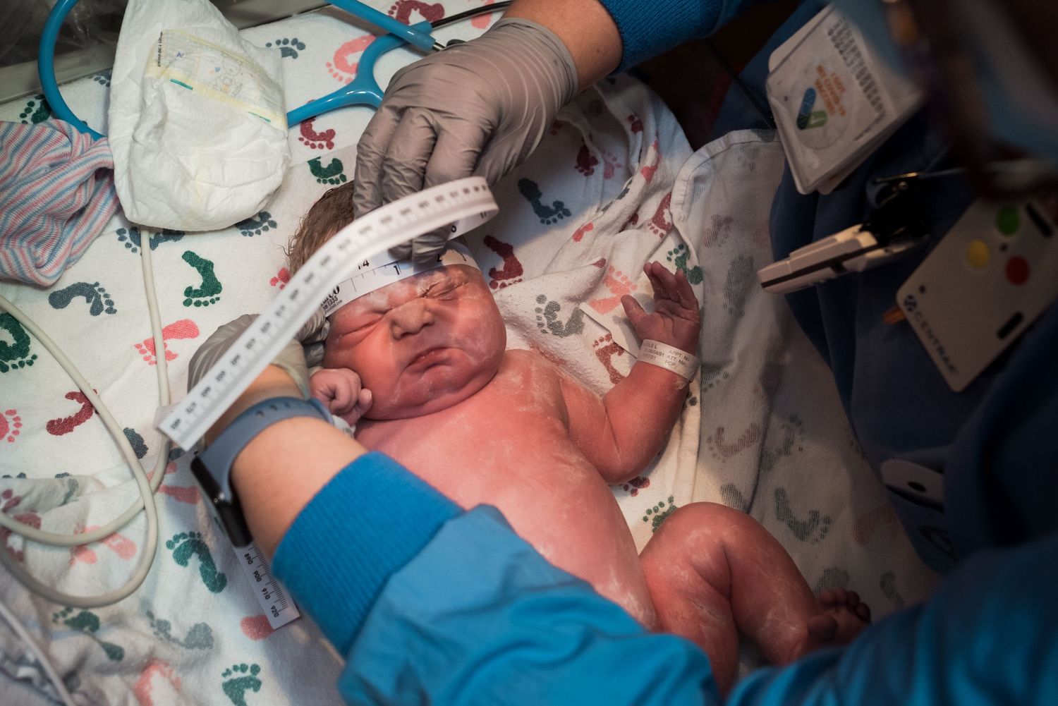 Medical team assists with newborn delivery in clinical setting.
