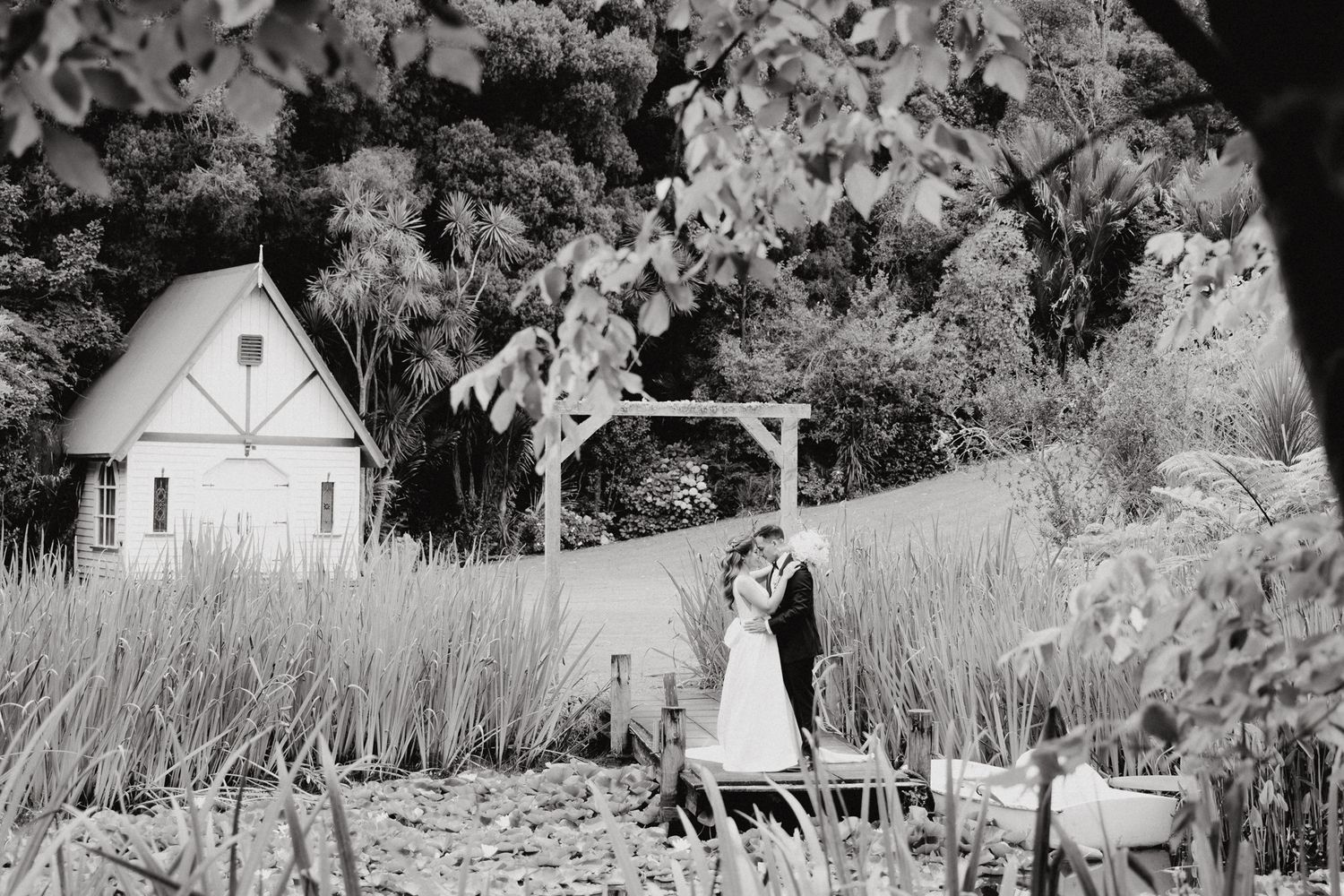 A romantic black and white wedding photo captured at a rustic garden venue by Apertured Media Auckland Wedding Photographer.