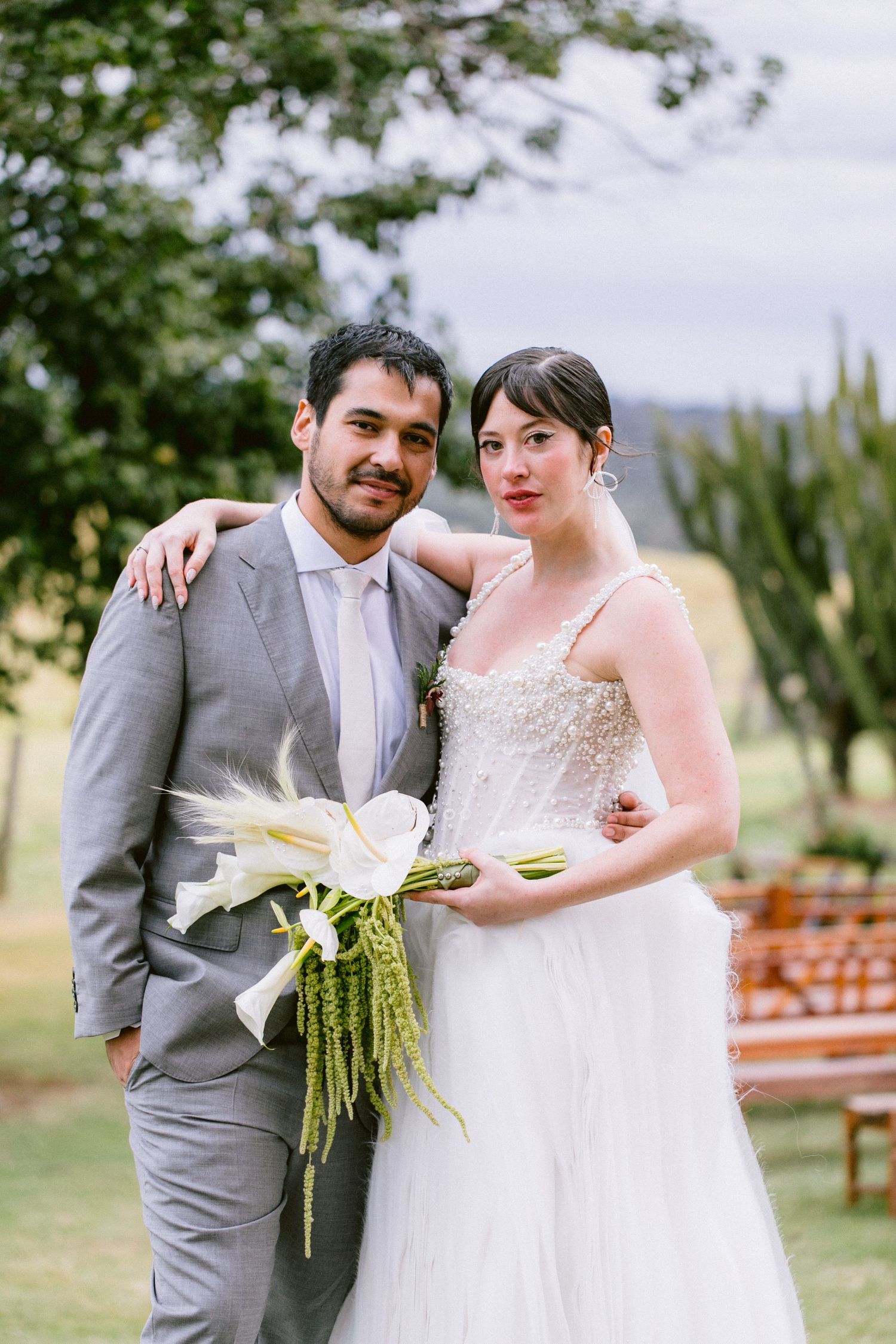 Wedding portrait in a garden with lily bouquet.