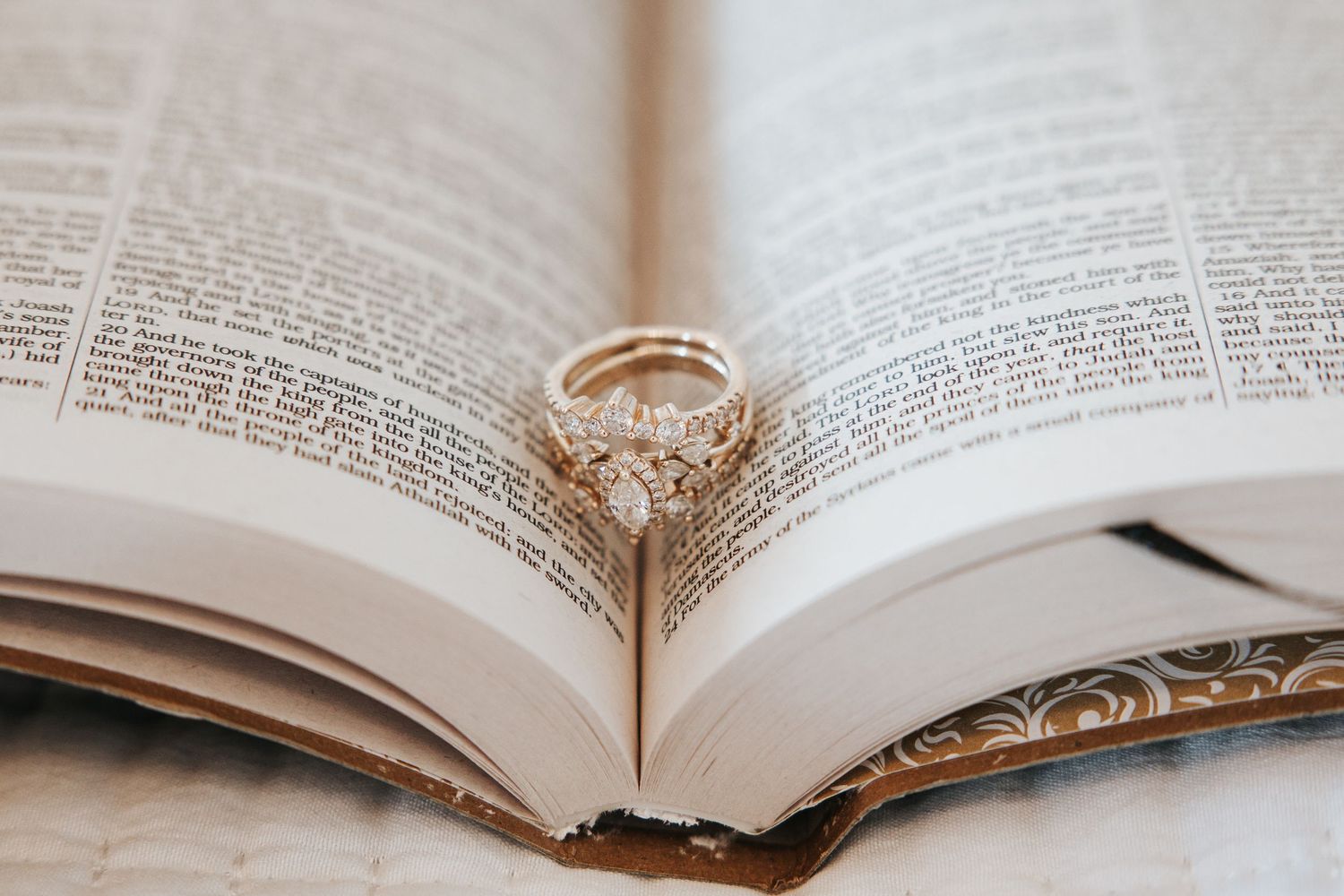 Diamond engagement ring resting between the pages of an open antique Bible on a wedding day, captured by Knoxville wedding photographer Beth