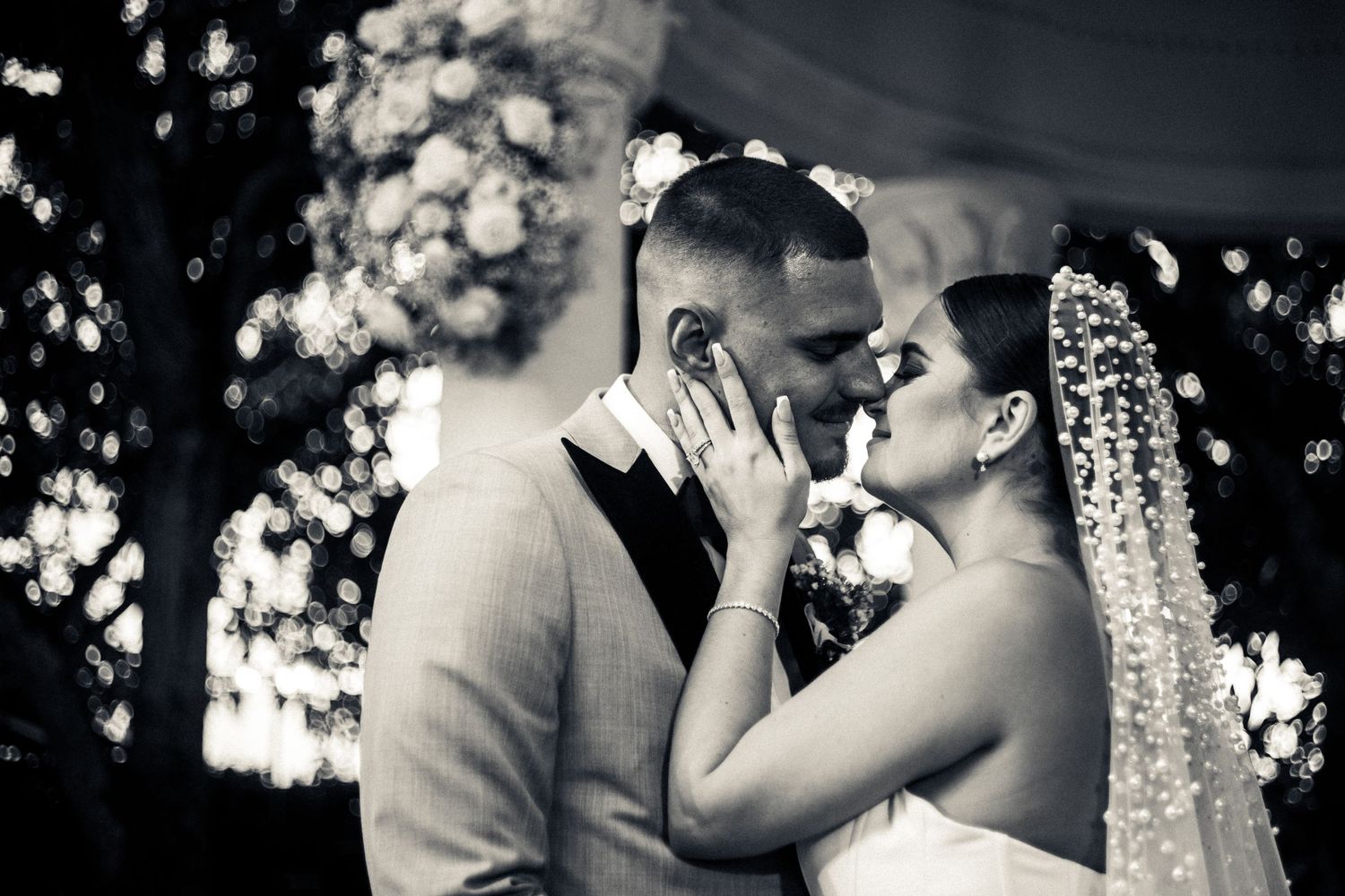 Dramatic black and white photo of couple sharing tender moment during wedding.