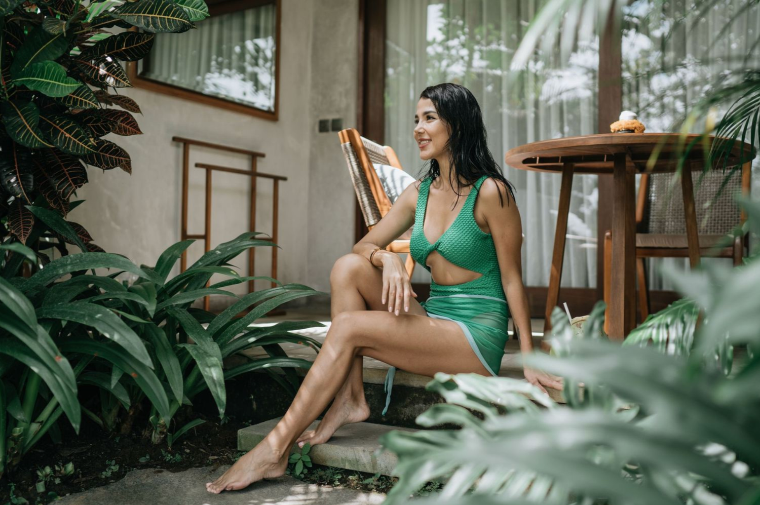 Serene swimming pool scene surrounded by tropical greenery and natural lighting.