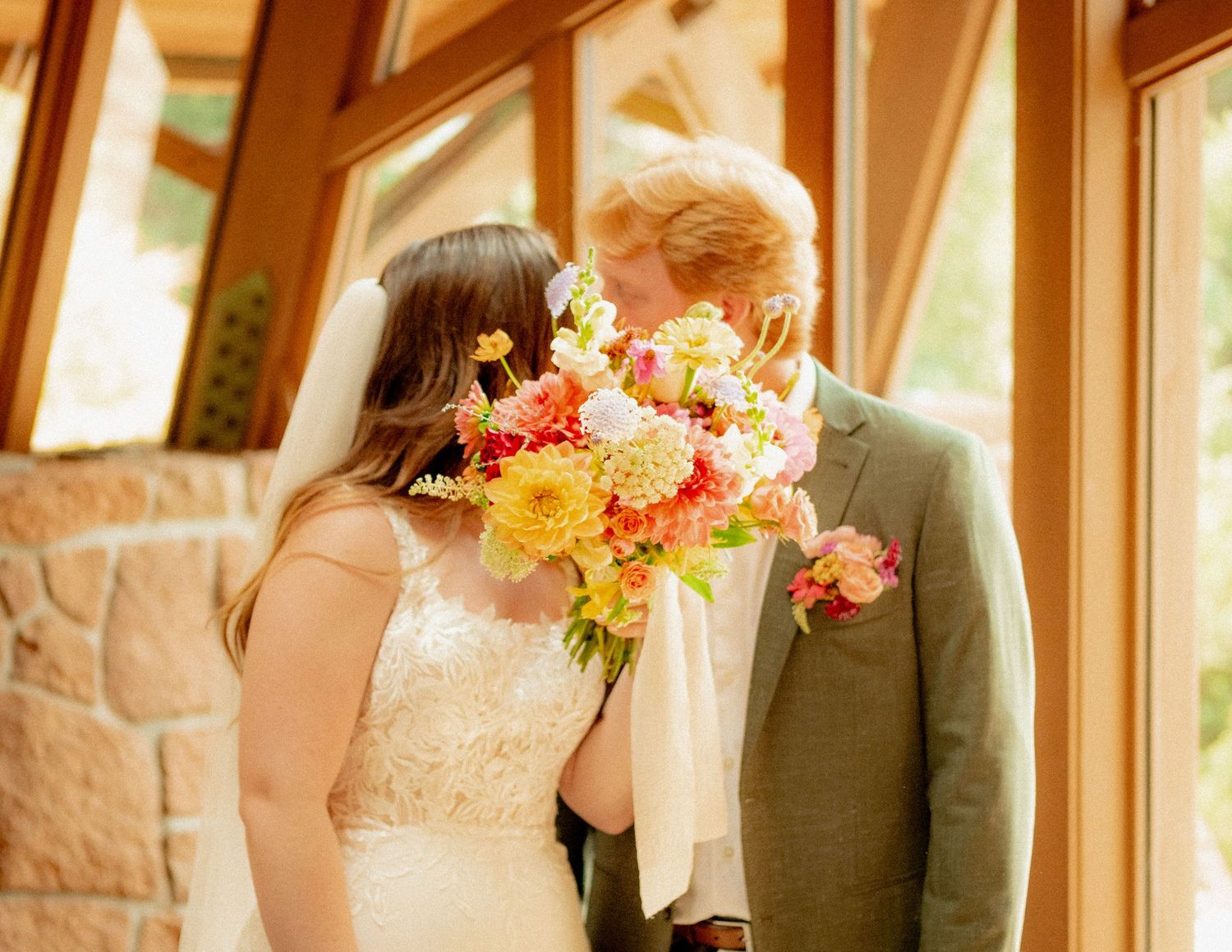 Wedding ceremony details with sunlit windows and colorful floral bouquets.