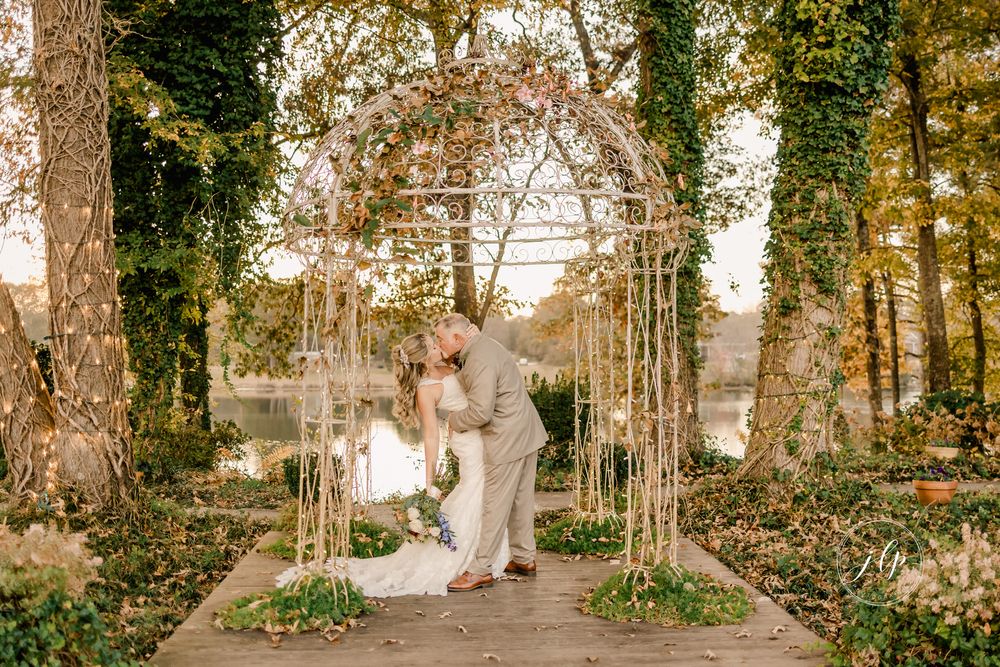 Elegant couple shares romantic moments in a sunlit forest setting with autumn foliage and tall trees.