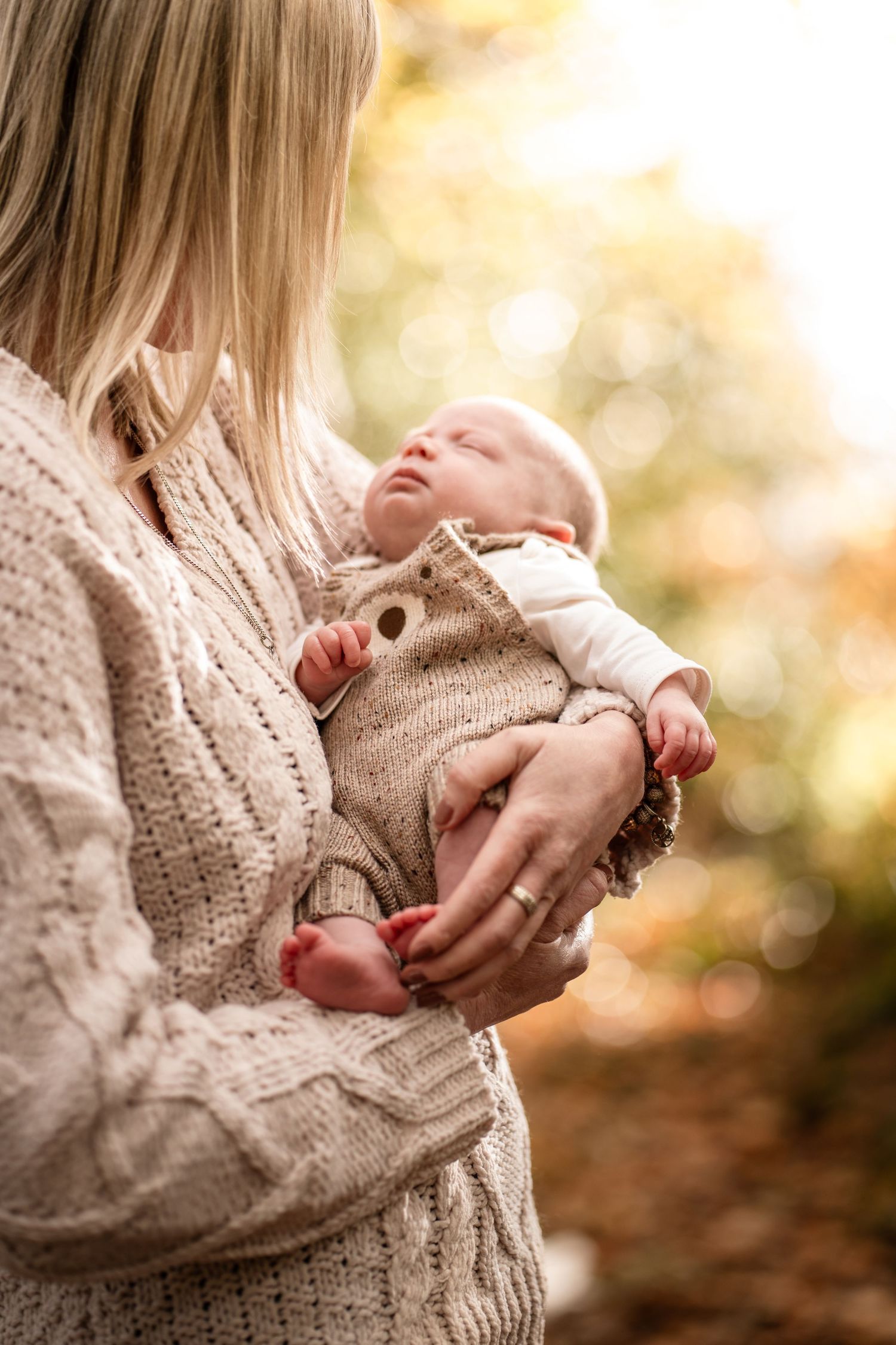 A parent shares a tender moment with their baby against a warm autumn backdrop in a series of connected photos.