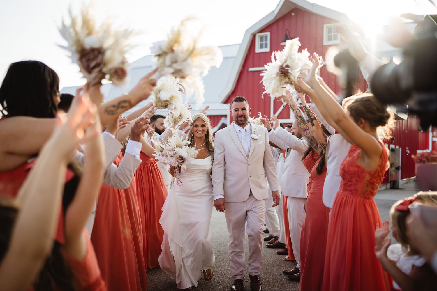 A couple embraces during their sunset wedding photo session in a lush outdoor field.