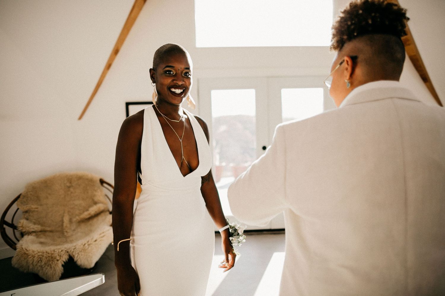 Bright minimalist room with sunlight streaming through windows during wedding preparations.