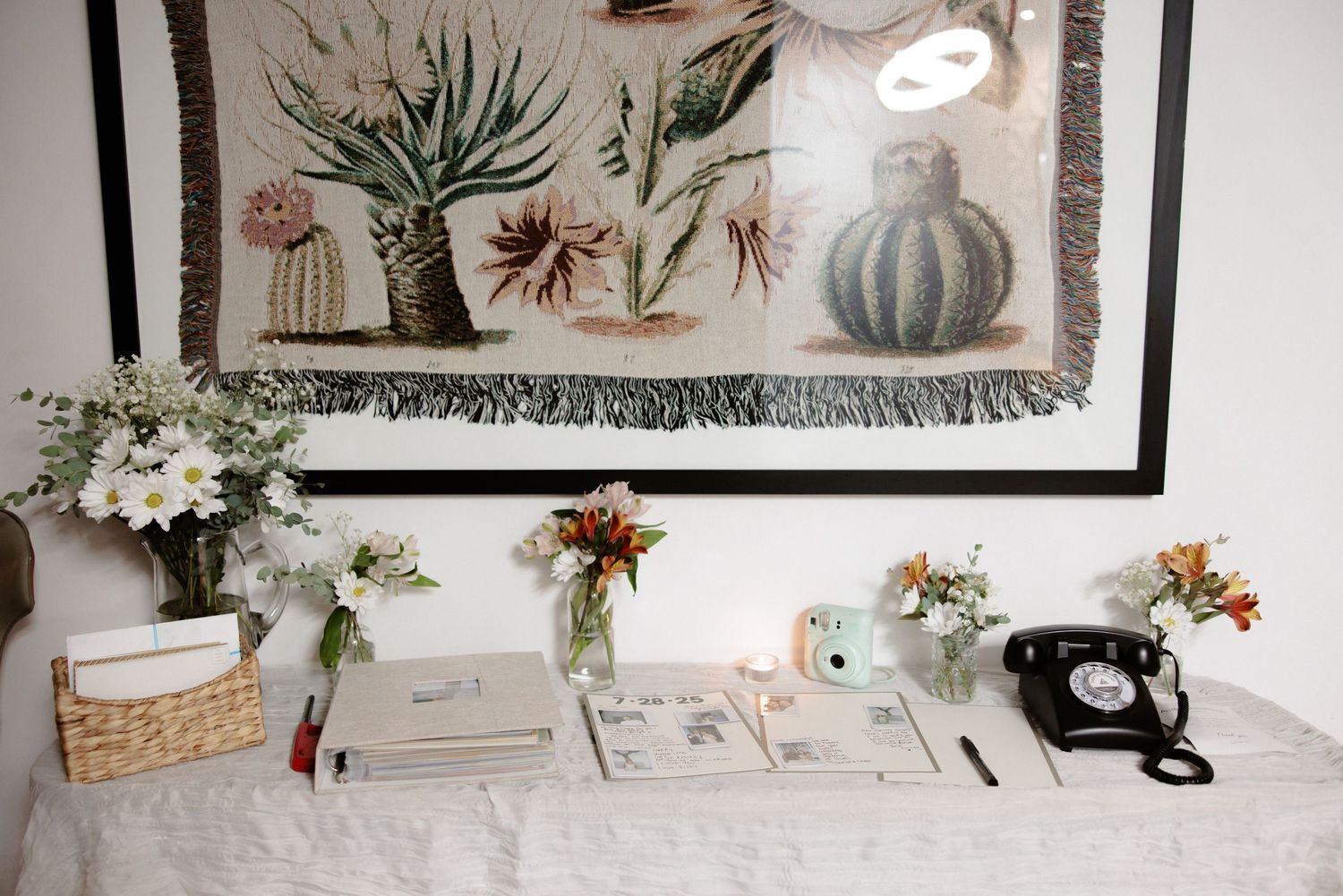 A collection of vintage and modern home decor items displayed on shelves, including art prints and greenery.