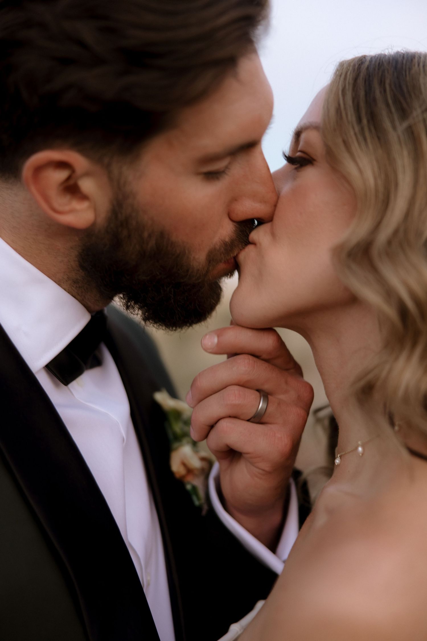 A romantic sequence of wedding photos showing a couple sharing an intimate kiss outdoors.