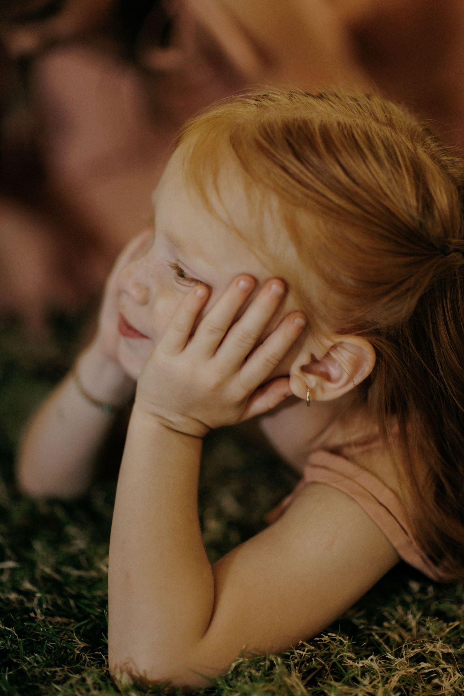 A series of artistic close-up photos showing hands covering ears in varying poses against a natural outdoor background.