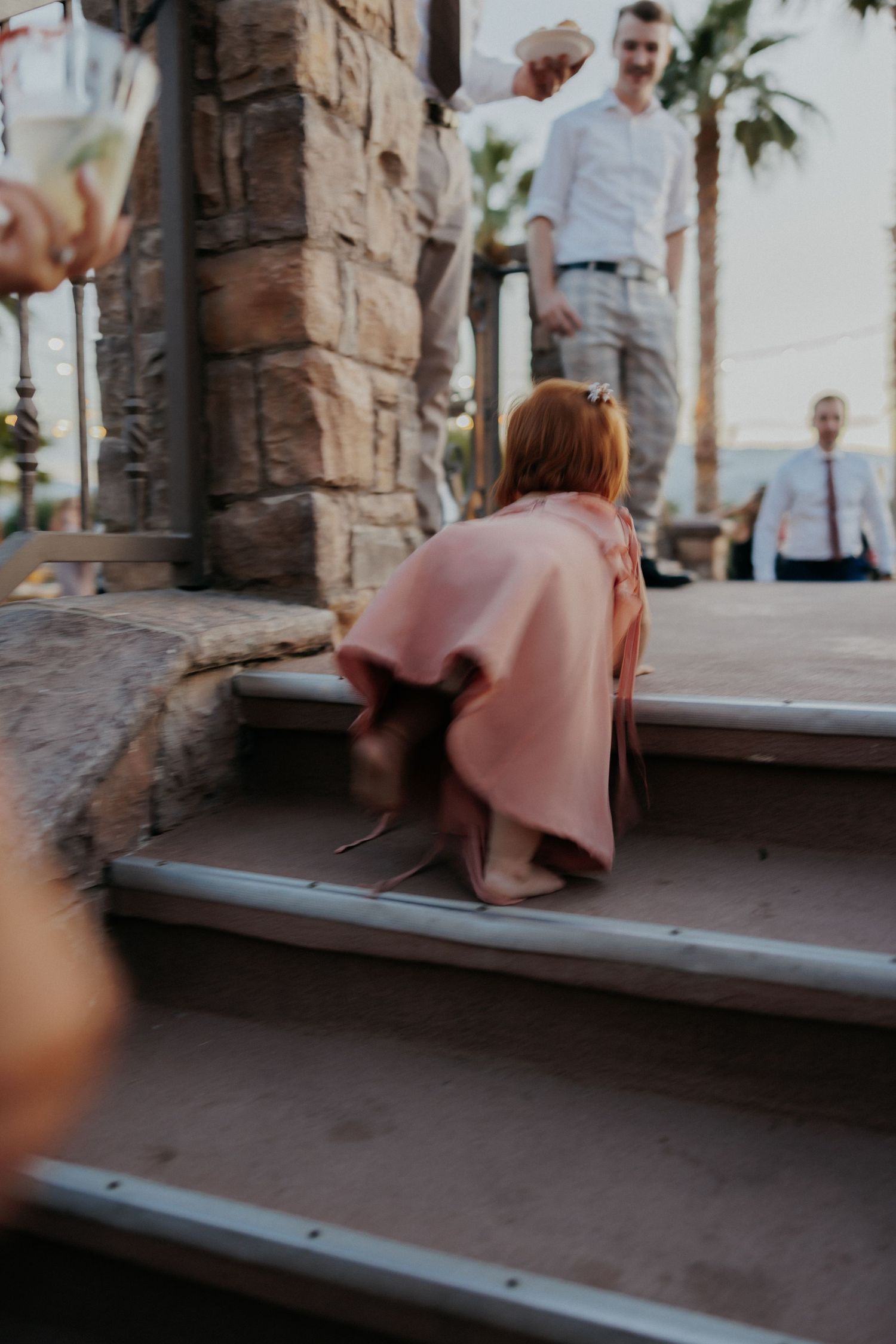People sit together on a stone bench in a rustic Mediterranean setting during sunset.