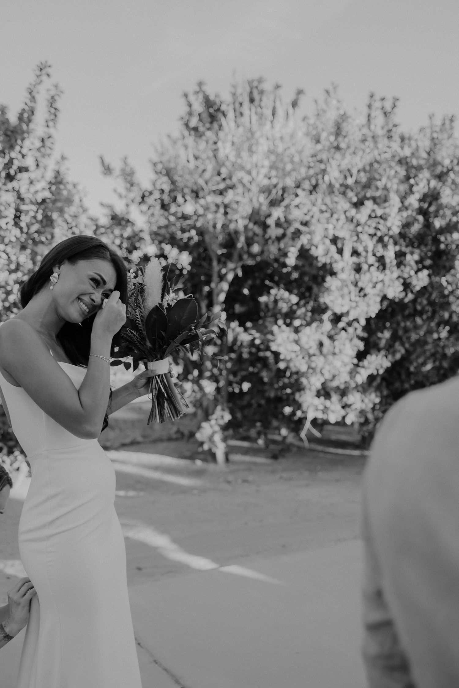 Black and white photo sequence of a person in a white dress twirling and posing in a sunny outdoor garden setting.