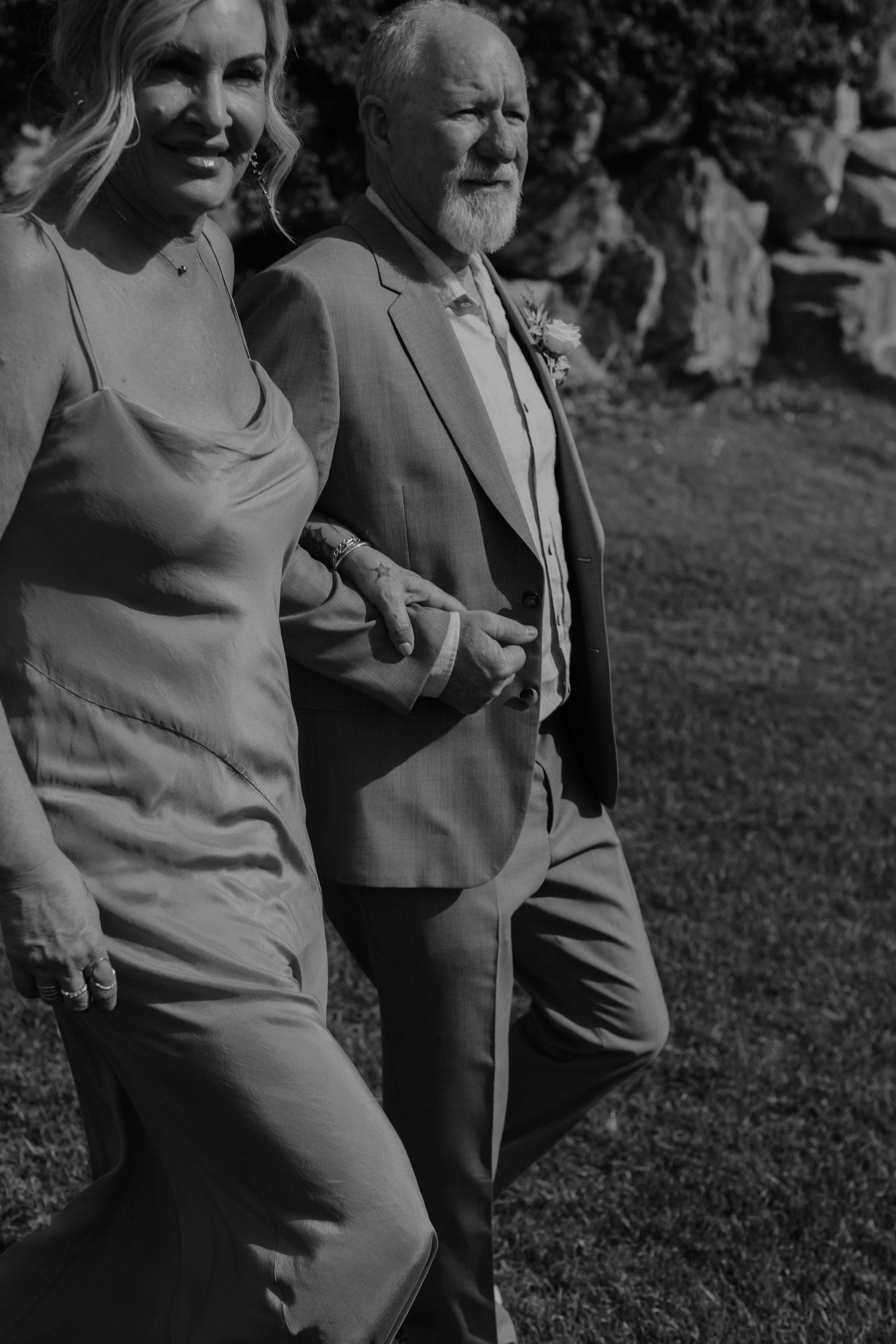 Black and white cropped repeat photo sequence of two people standing together on grass outdoors.
