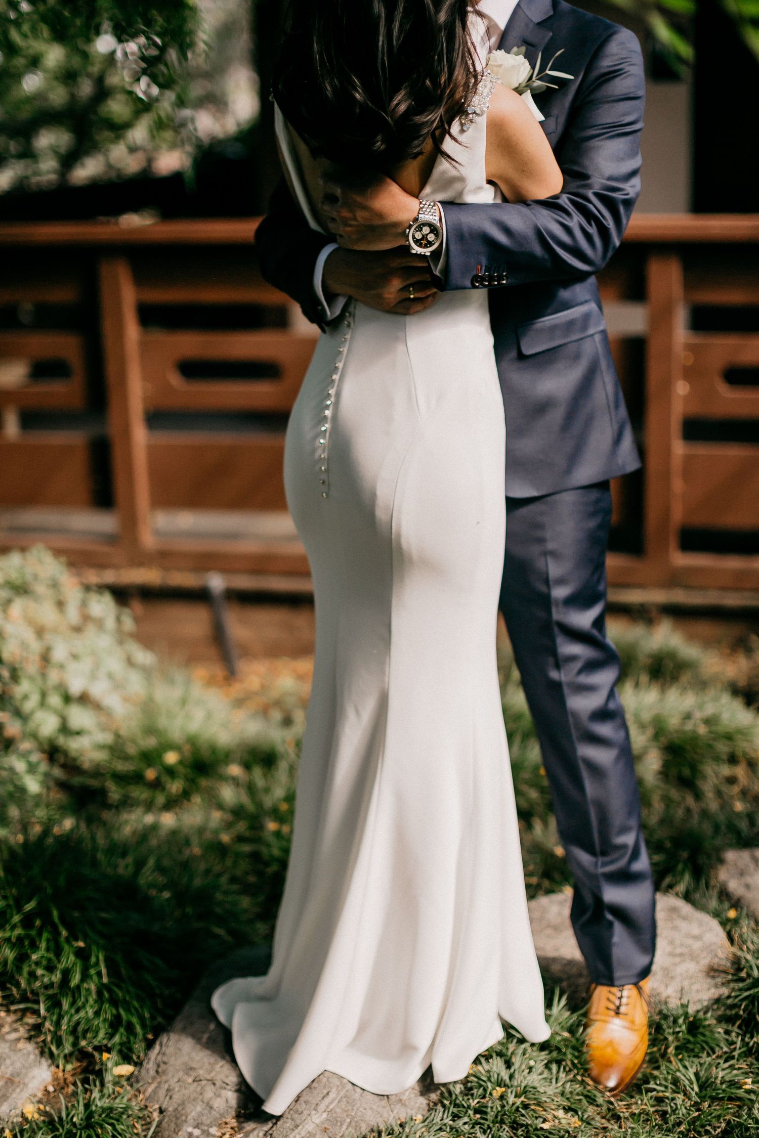 Close-up shot of shoes and dress hem during an intimate wedding ceremony outdoors in natural light.