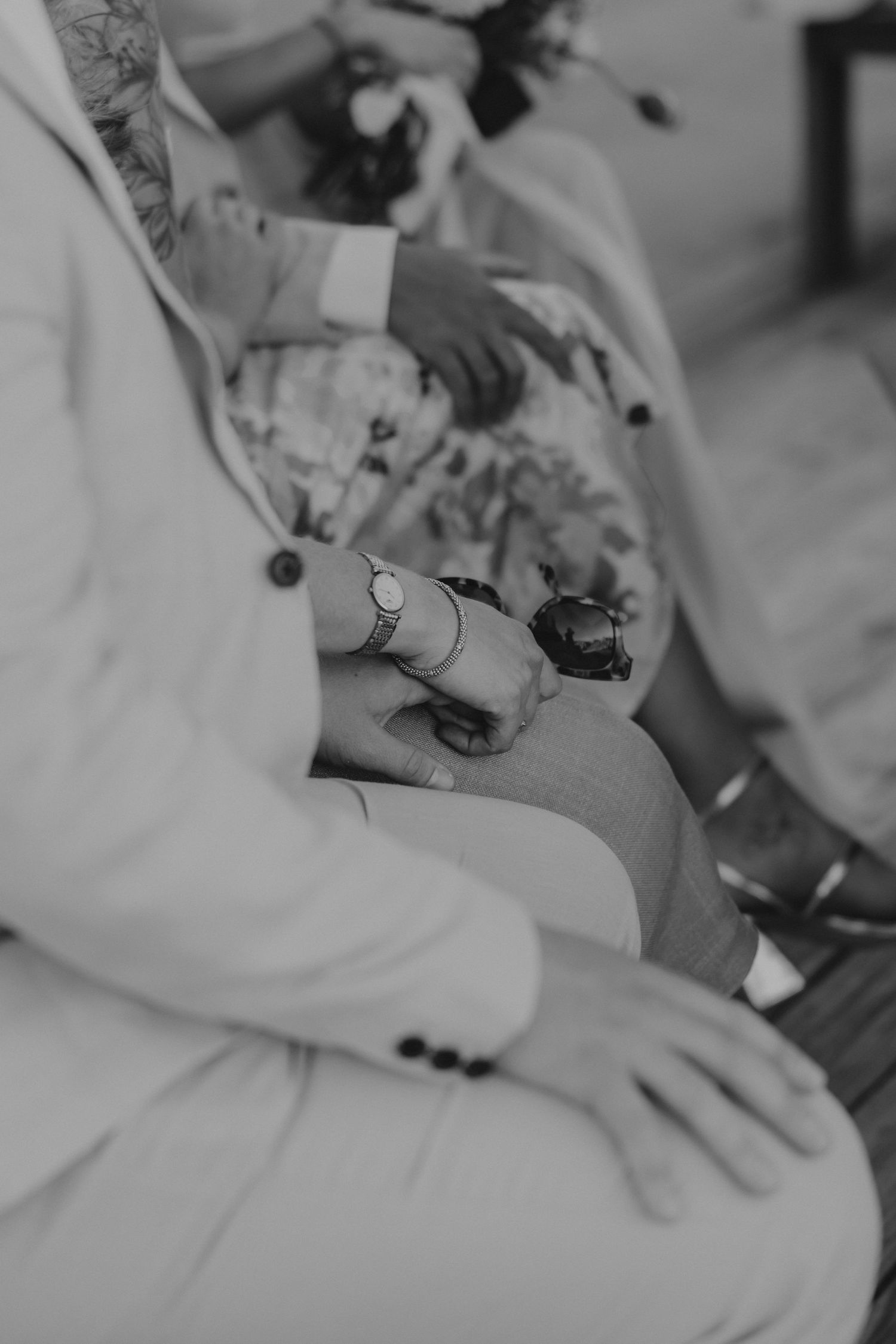 A black and white medical themed photo of hands wearing white medical coats at a formal gathering.