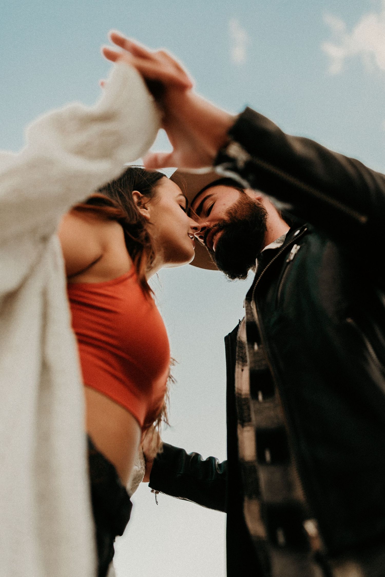 A romantic couple embraces passionately against a blue sky backdrop in an artistic composite of dance-like movements.