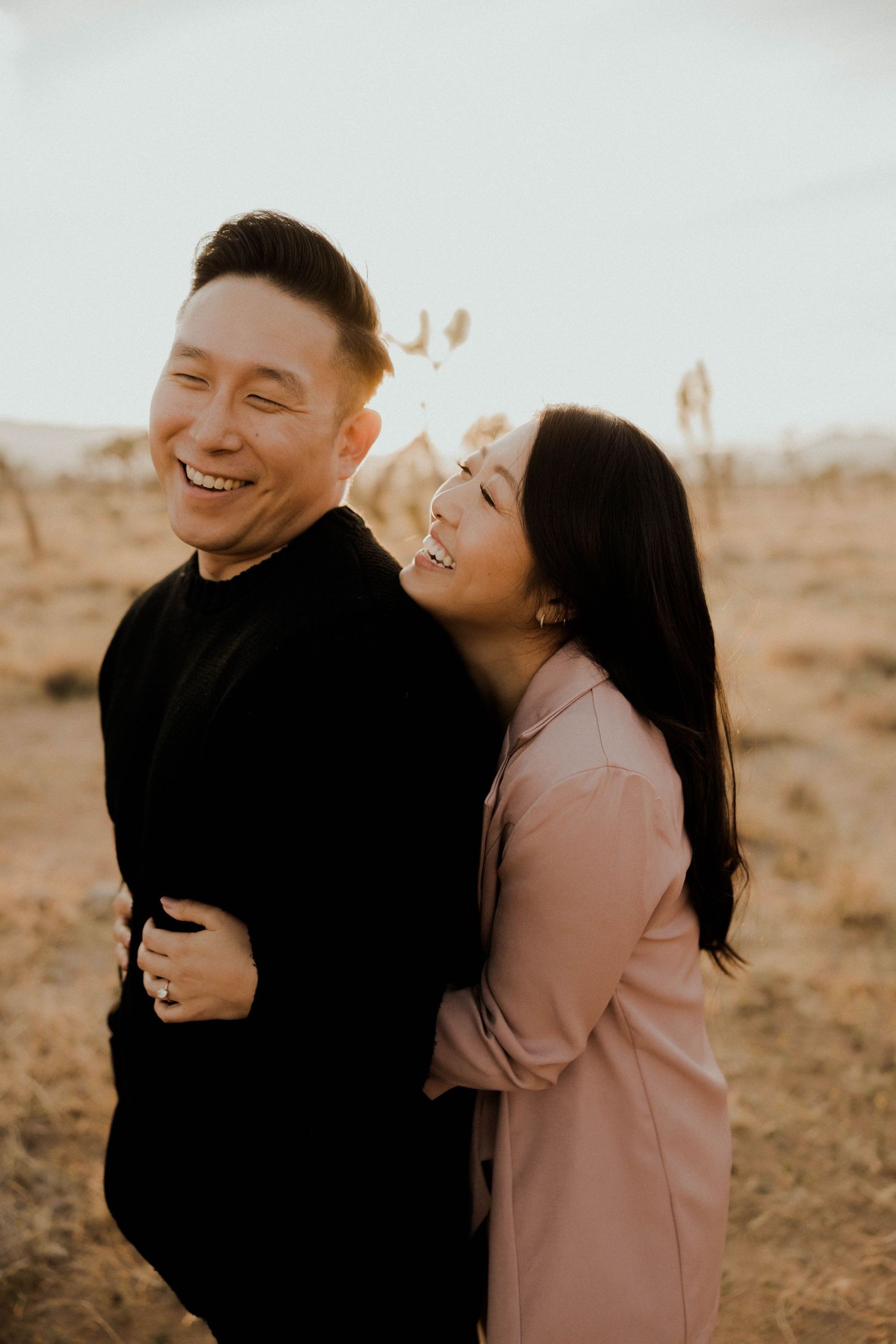 Candid moments of a couple laughing and embracing in warm sunlight against a desert landscape.