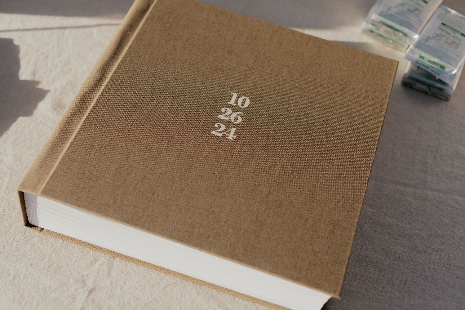 Neutral-toned linen fabric with numbered text shown in multiple cropped views on a dark surface.