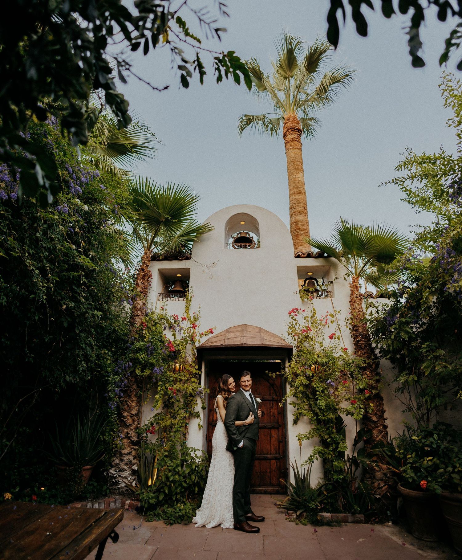 Row of archways framed by palm trees at a wedding venue with elegant Spanish colonial architecture.