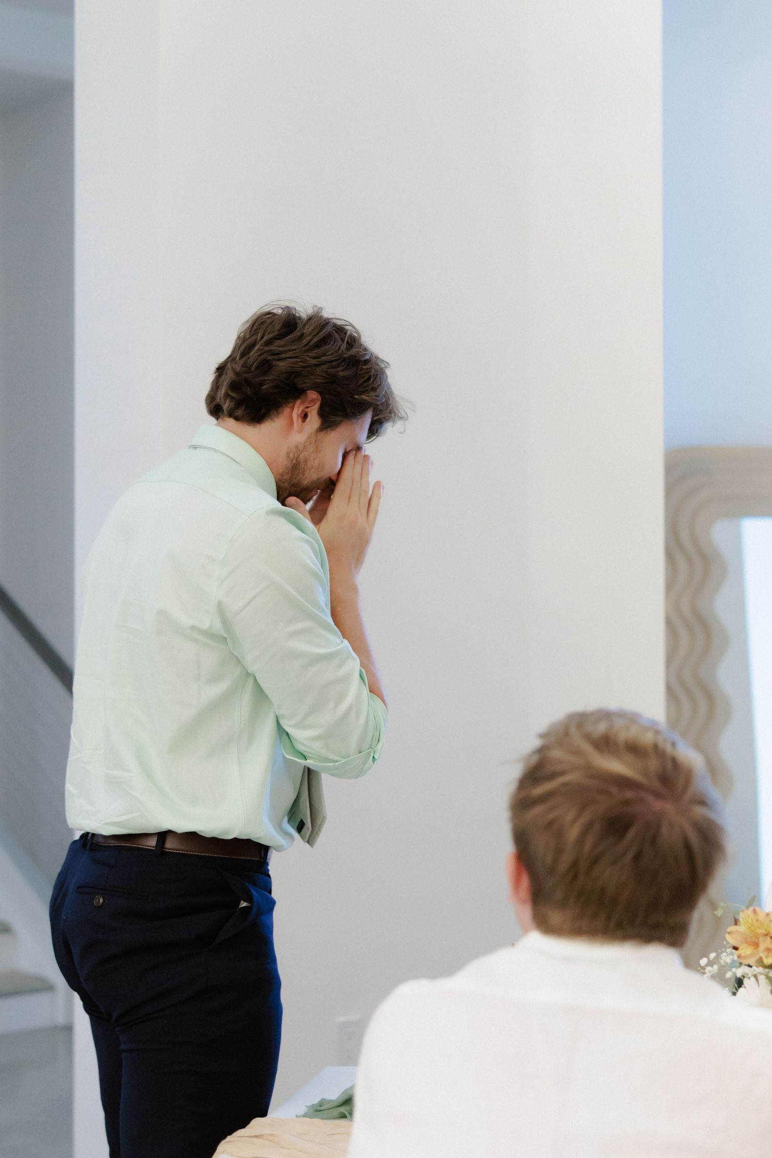 A sequence of images showing a person in light colored shirt and dark pants leaning forward with head down while working.
