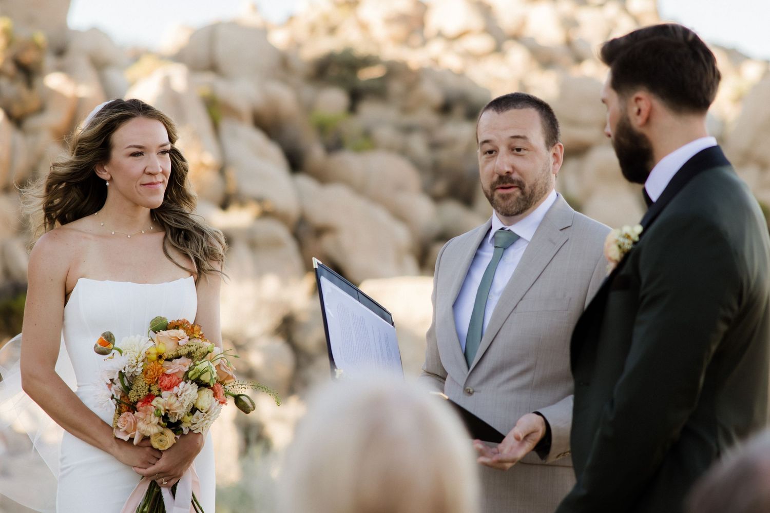 A collection of outdoor wedding ceremony photos with individuals exchanging vows amongst sunlit natural stone scenery.
