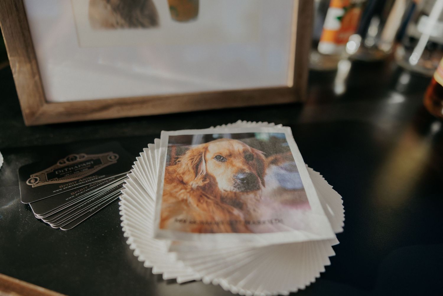 Collection of wedding photos spread out on a dark wooden surface in an artistic arrangement.