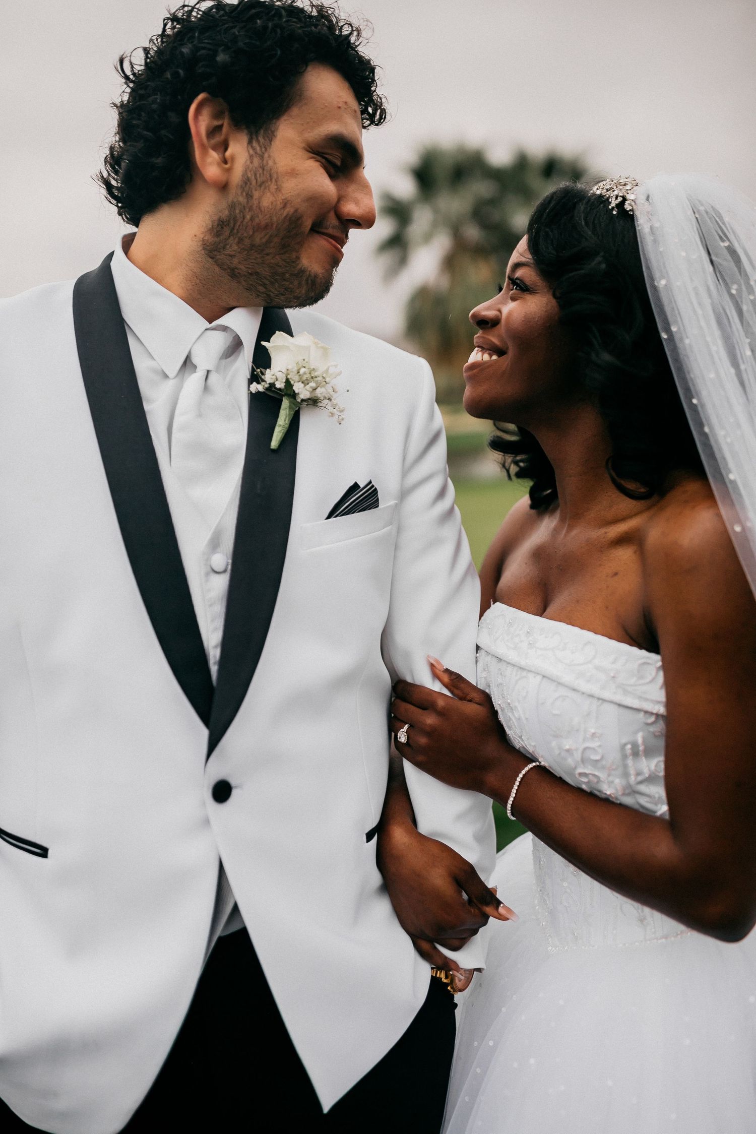 A newlywed couple shares a joyful moment together in formal wedding attire.
