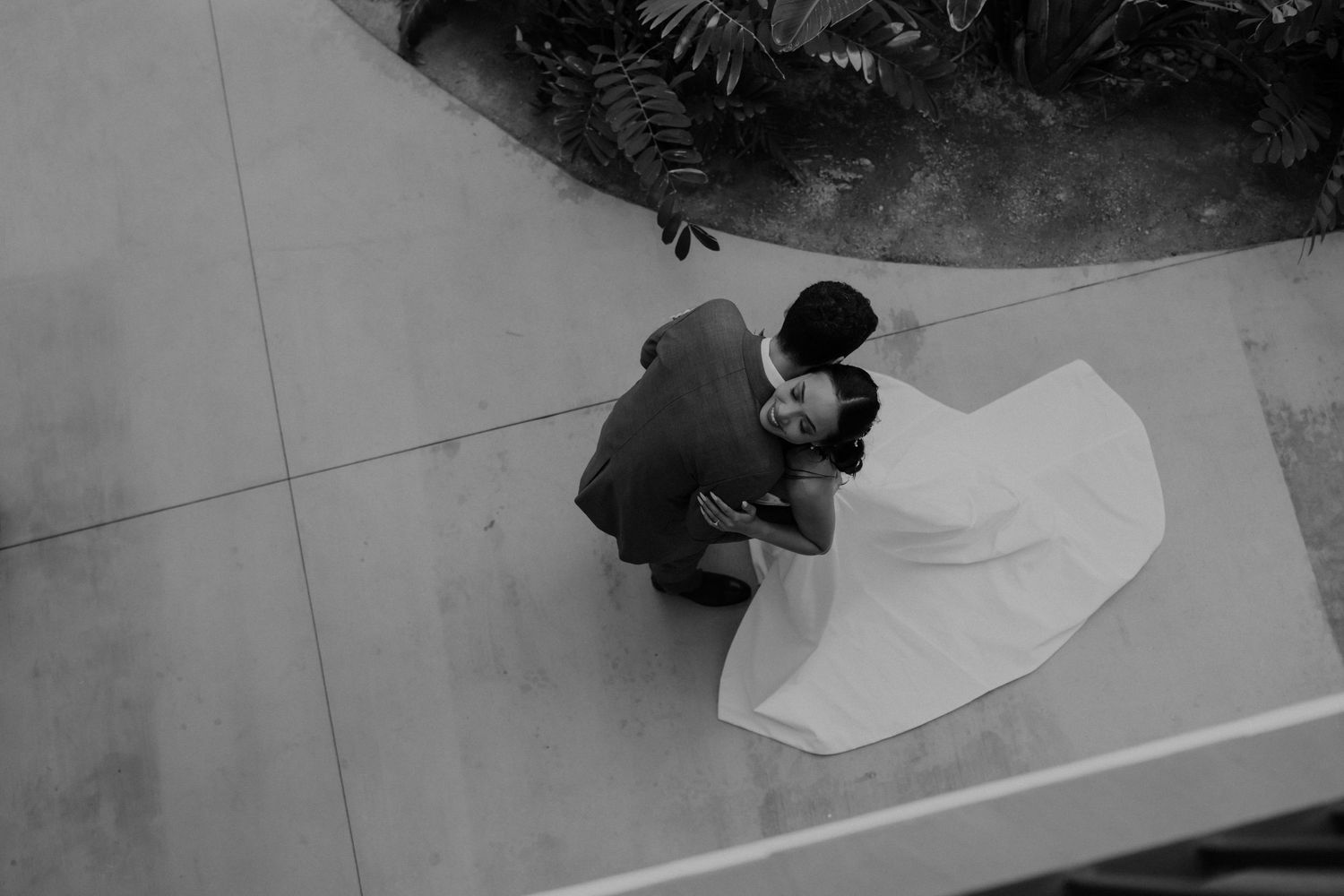 Two people practice dance moves in a ballet studio with a white dance floor.
