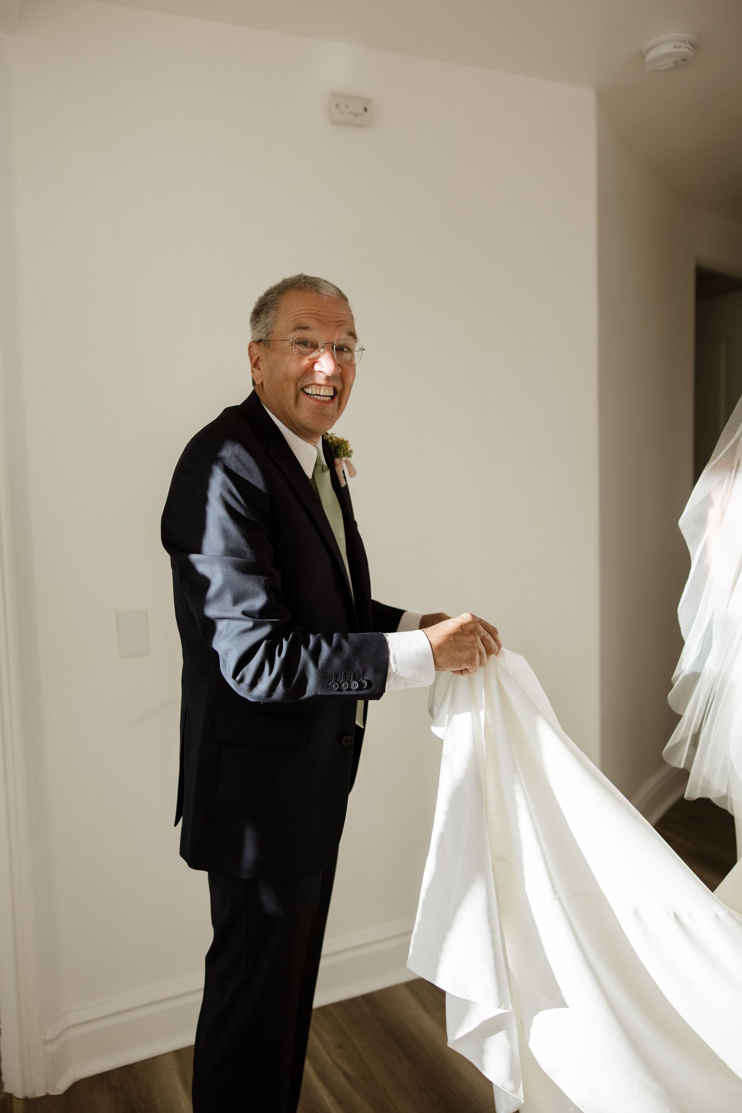 Four sequential photos showing someone in a dark suit pulling back billowing white curtains in a bright interior space.
