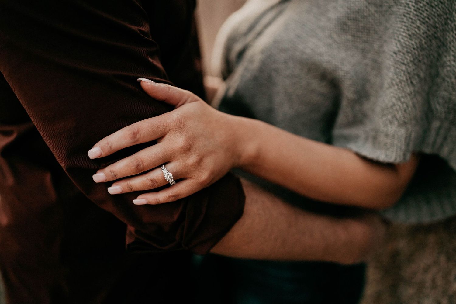 Close-up of hands with wedding rings showing intimate moments between a couple in muted tones.