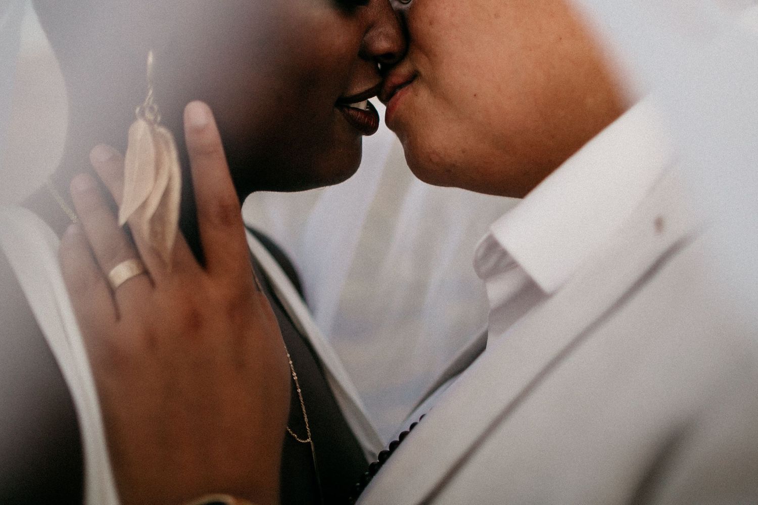 Close up romantic wedding photo showing gentle affection between two people in formal attire.