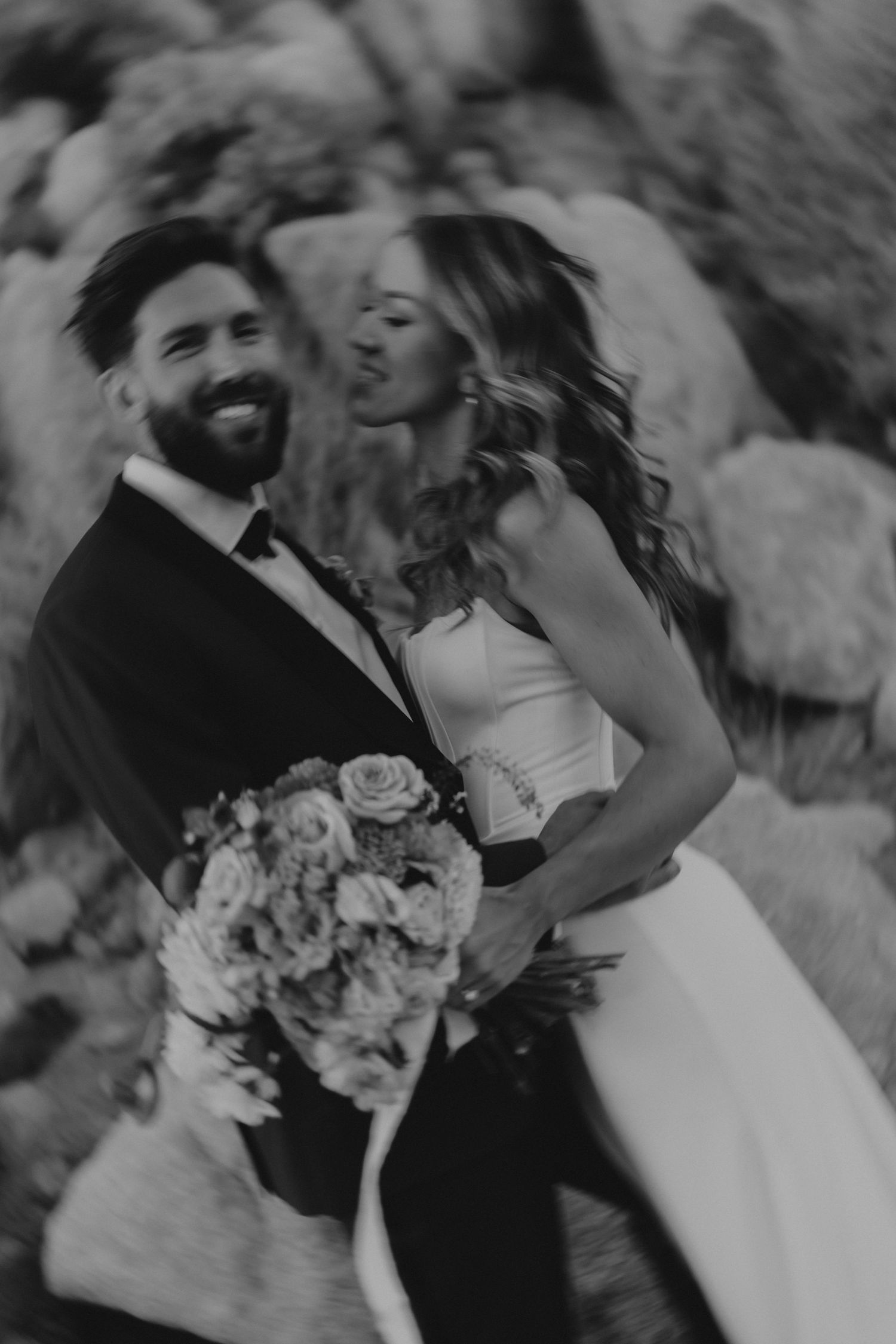 Black and white wedding photos show romantic moments between newlywed couple holding flower bouquets in outdoor setting.