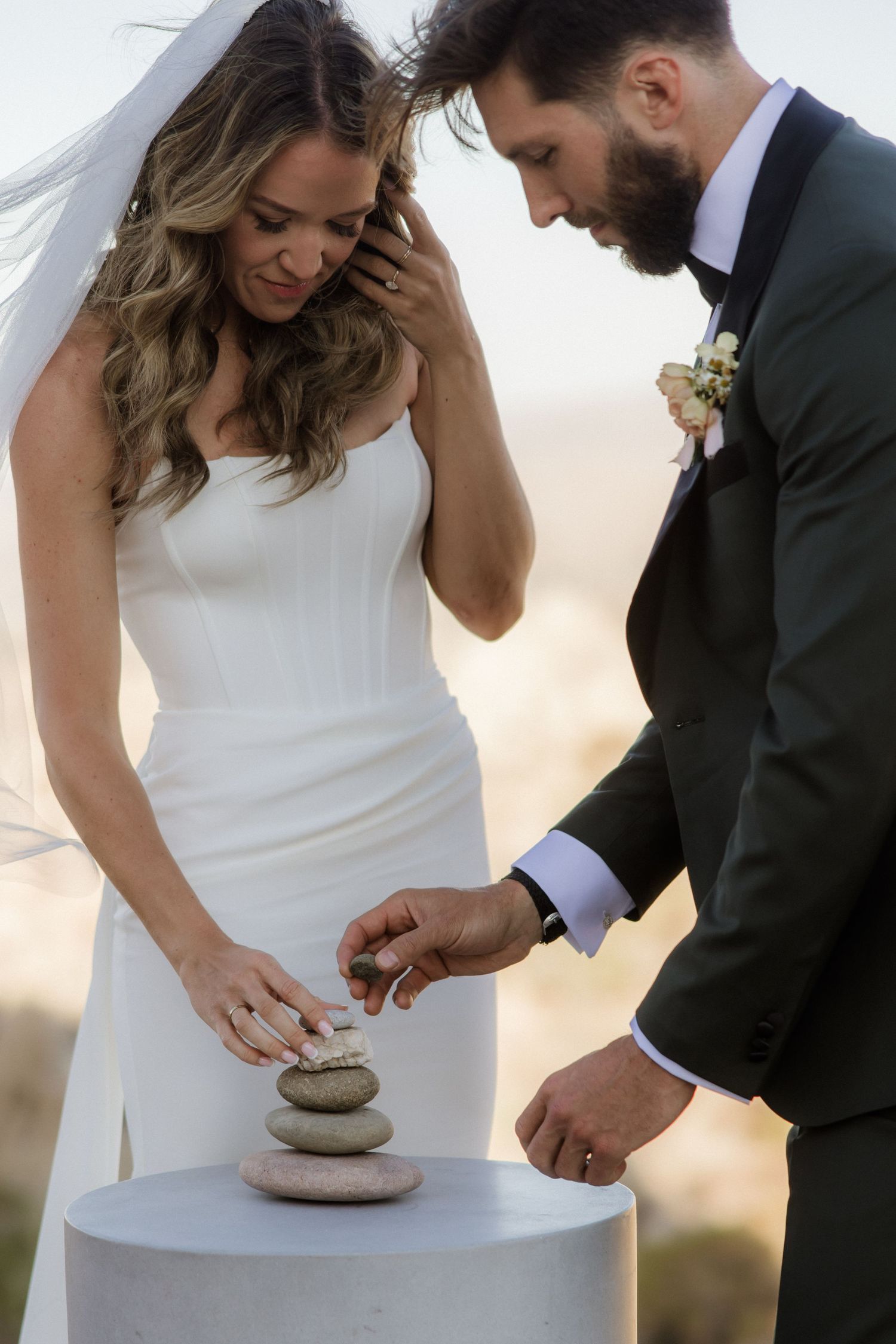 A couple performs a unity ceremony creating art with sand in multiple wedding photos at sunset.